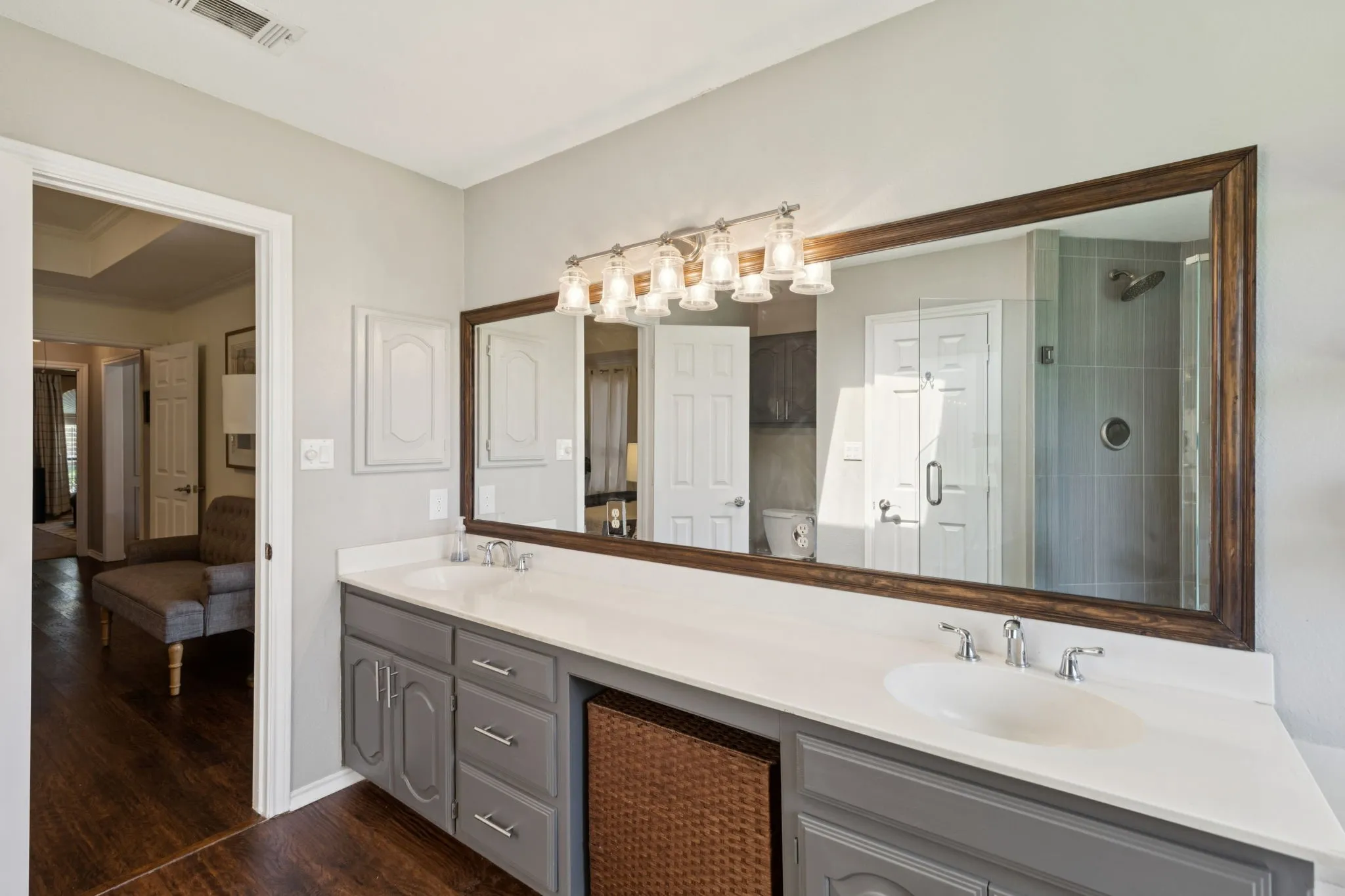 Double vanity with dual undermount sinks, gray cabinetry, and a light-colored countertop