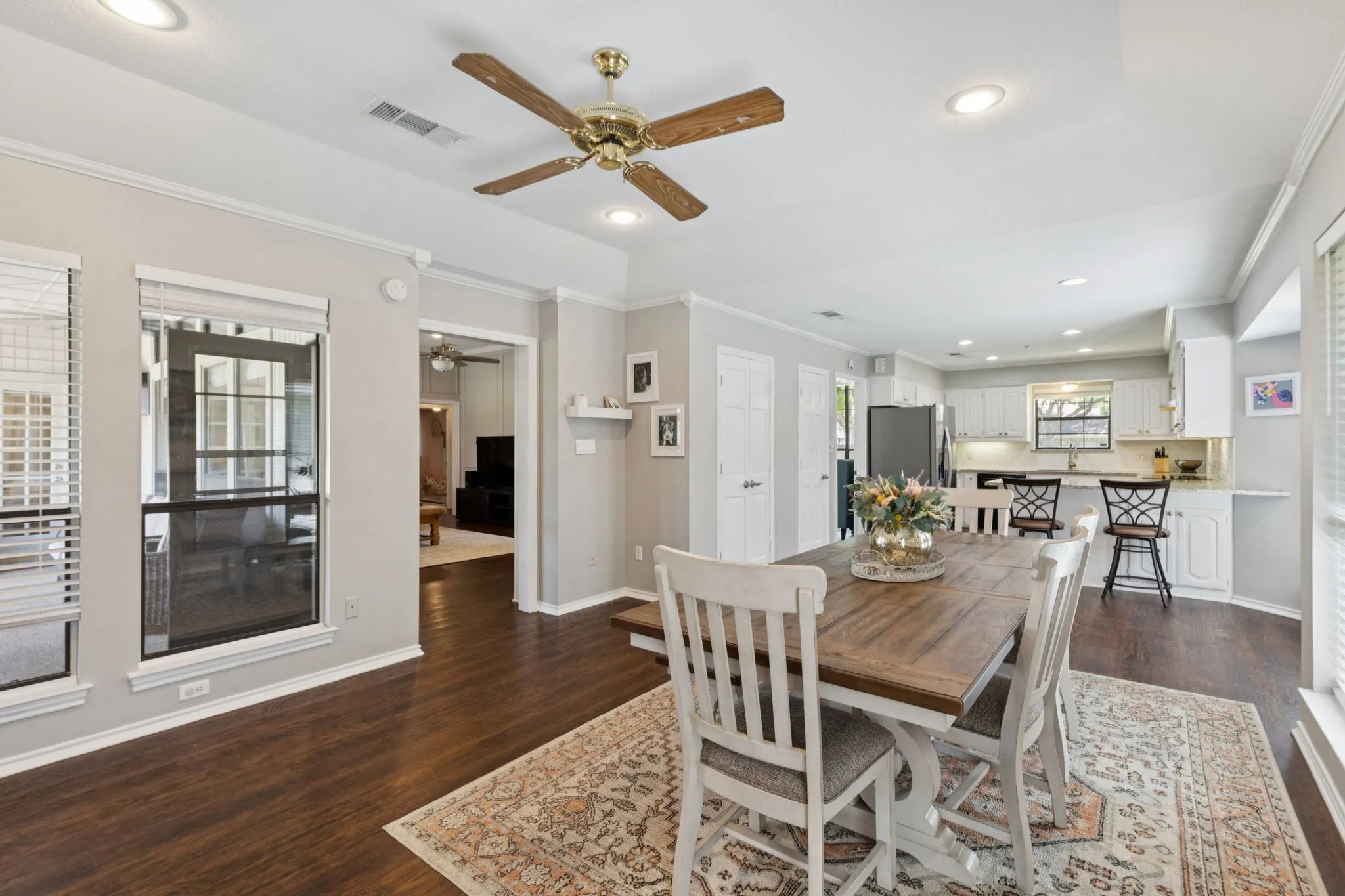 Open-concept dining area with wood-finish flooring, recessed lighting, and a ceiling fan
