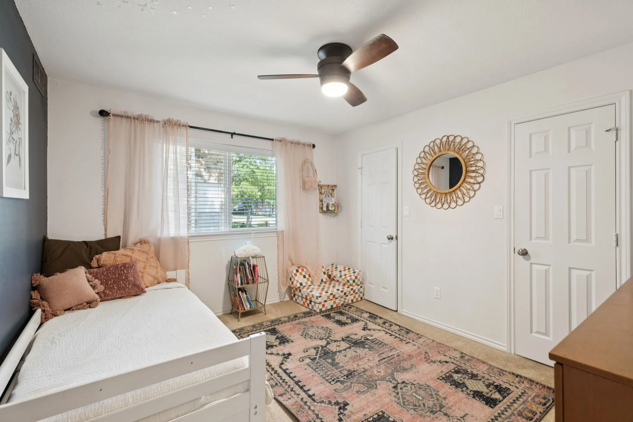 White interior walls with an accent wall, white trim, and a ceiling fan with light fixture