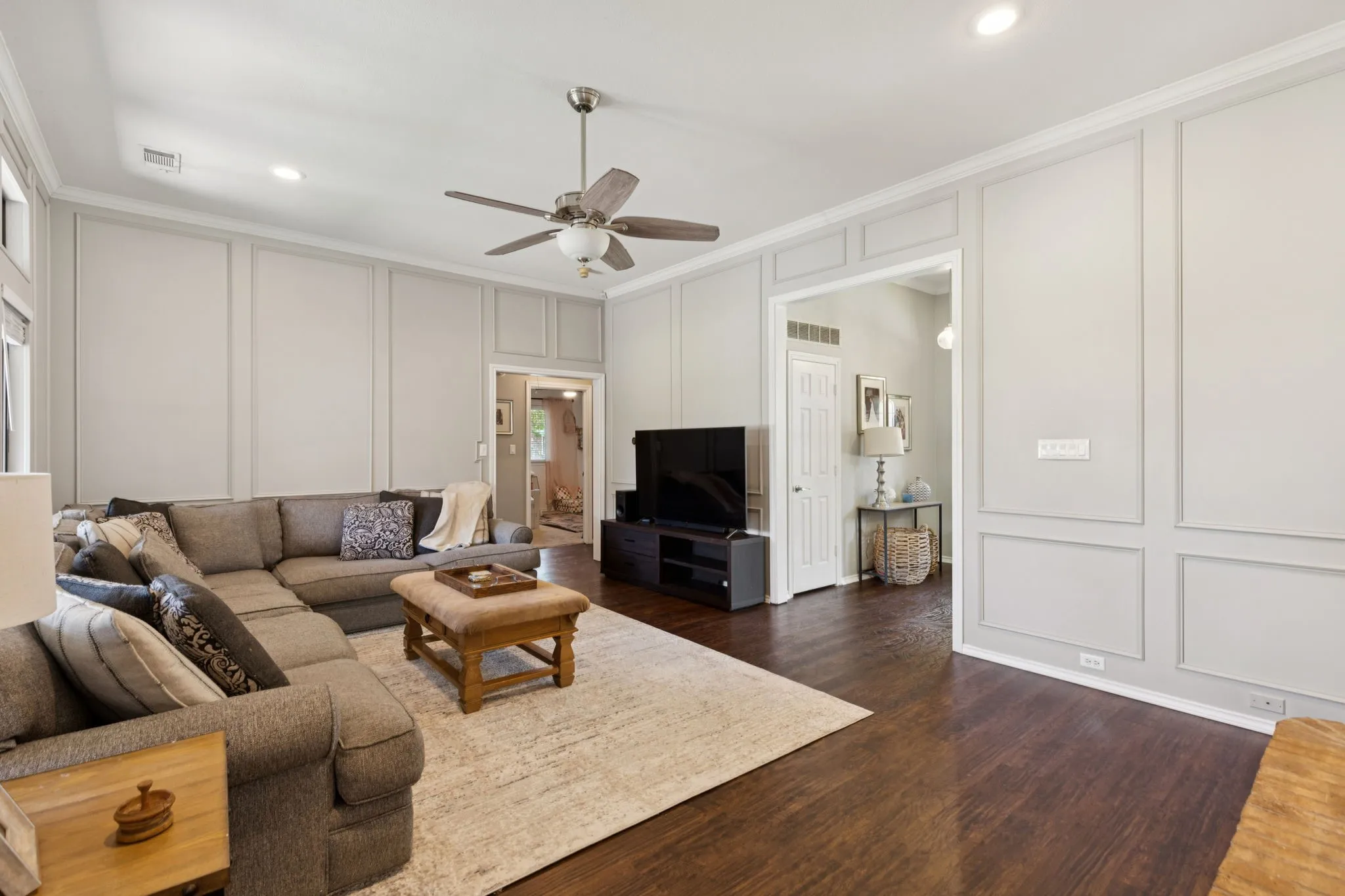 Dark wood-finish flooring, recessed lighting, and wall paneling