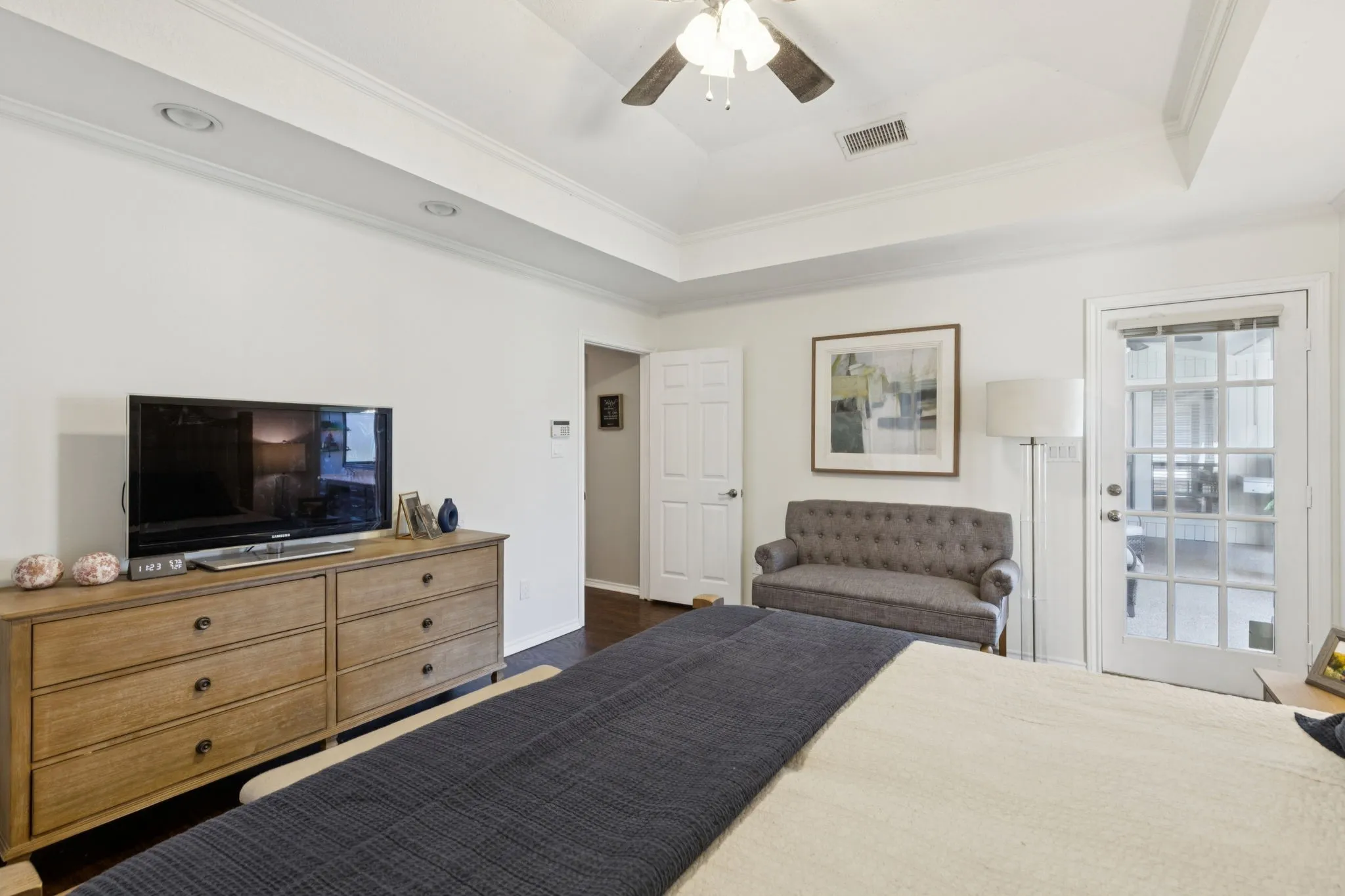 Tray ceiling with recessed lighting, wood-finish flooring, and a ceiling fan