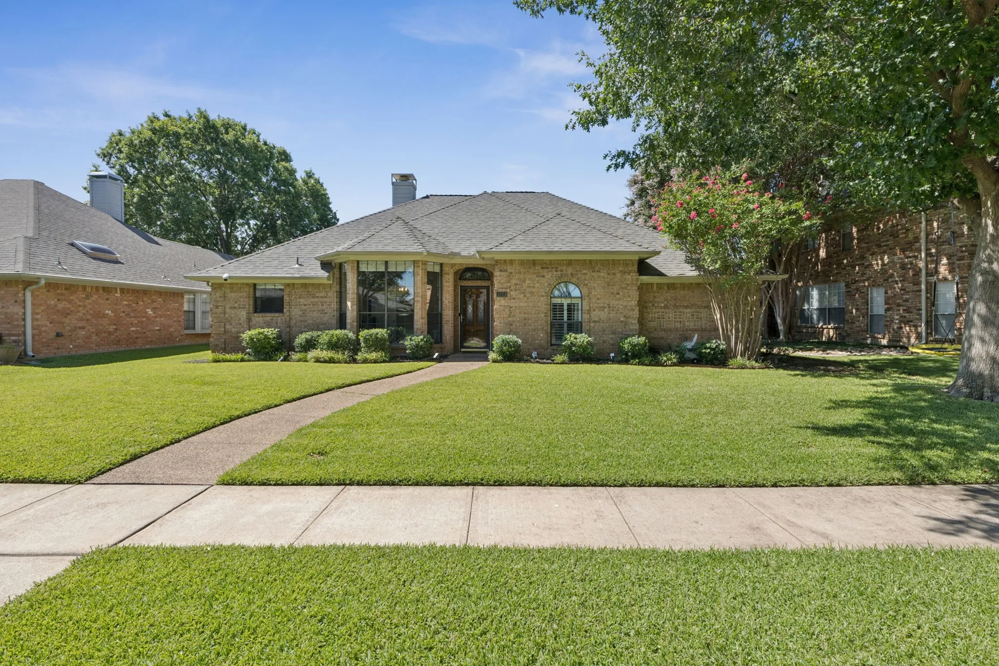 Brick exterior, gabled roof, arched entry, bay window, landscaped front yard