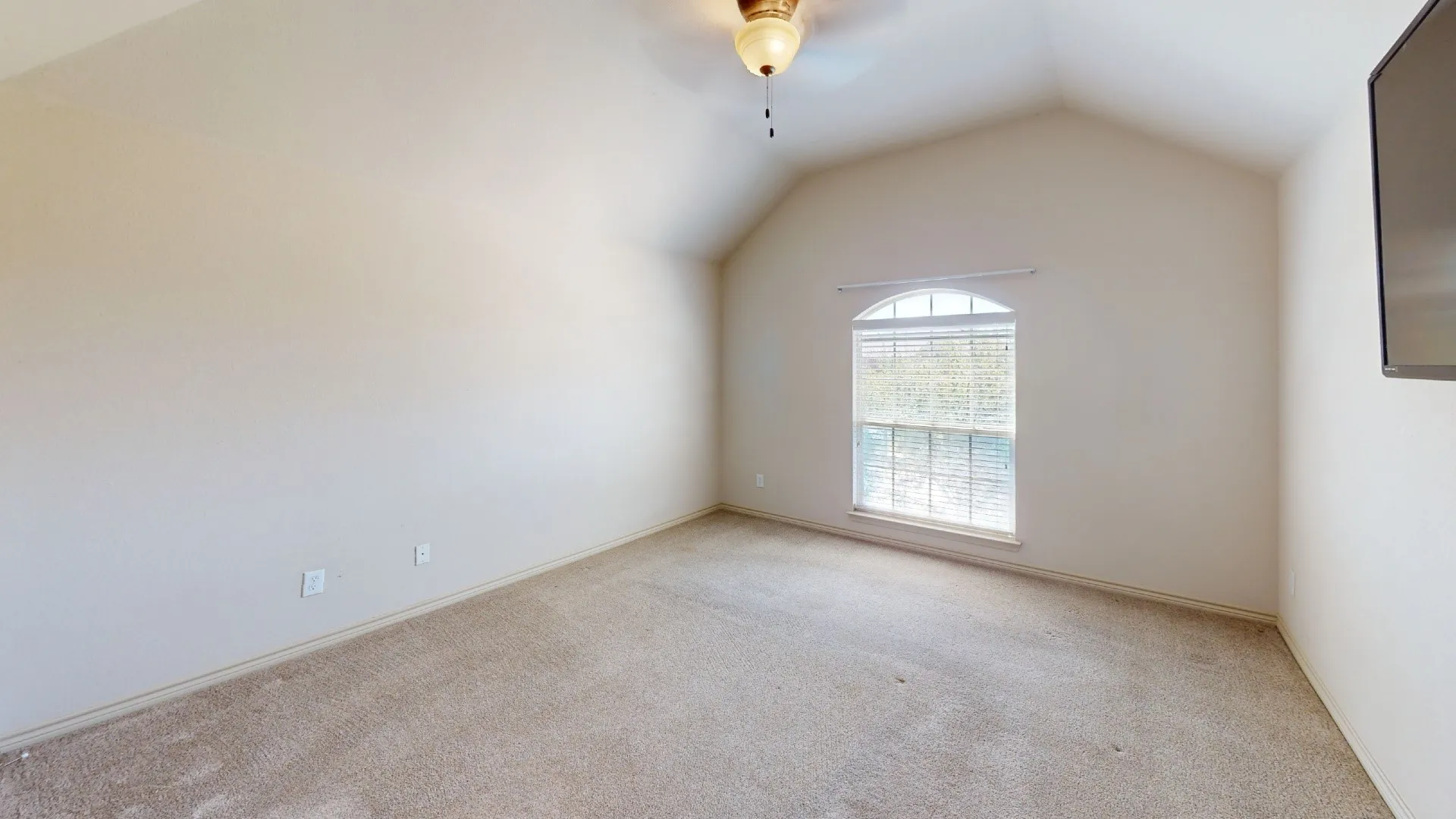 Vaulted ceiling, arched window with blinds, and ceiling fan