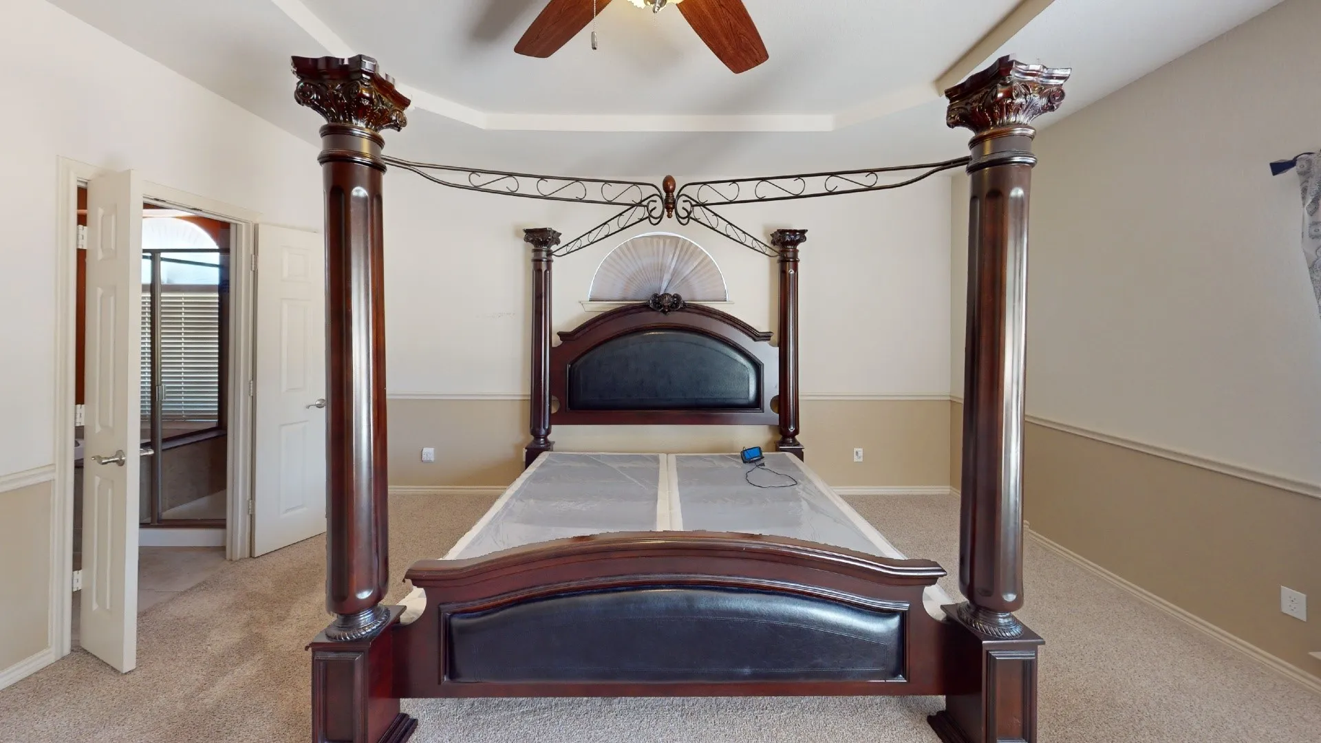 Tray ceiling with a ceiling fan, neutral wall colors, and carpet flooring