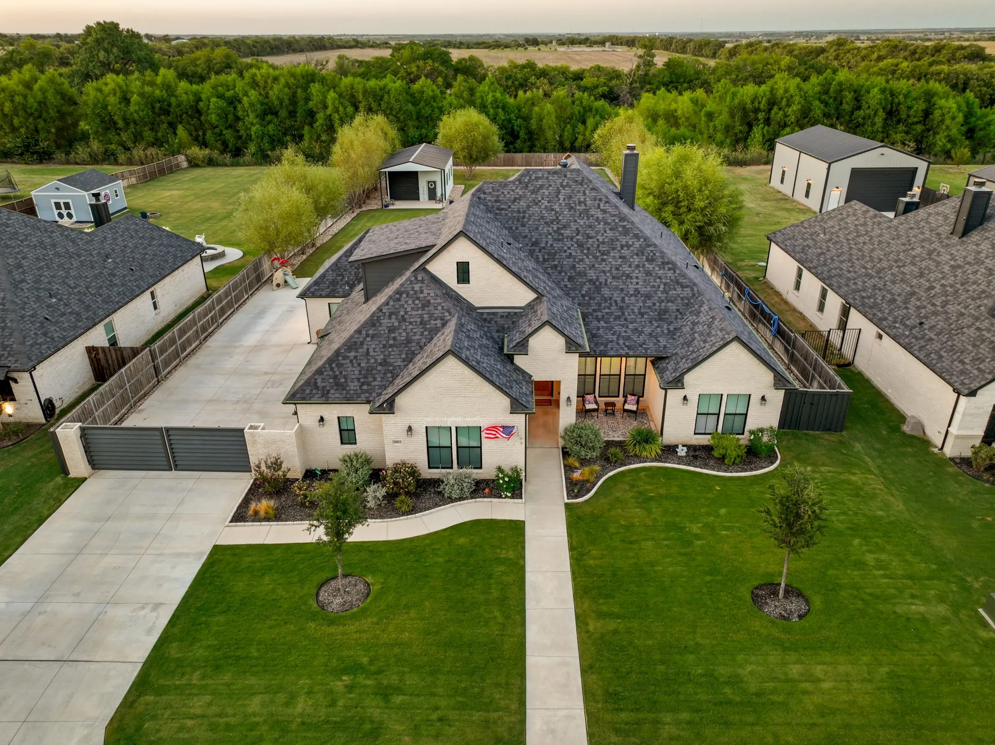 A sweeping 103-foot-wide driveway creates an unforgettable arrival, while every space beyond it reveals another layer of intricate design. Inside, soaring ceilings, 8-foot doors, vaulted wood beams, designer lighting & dramatic floor-to-ceiling ledgestone fireplace establish an atmosphere of refined comfort