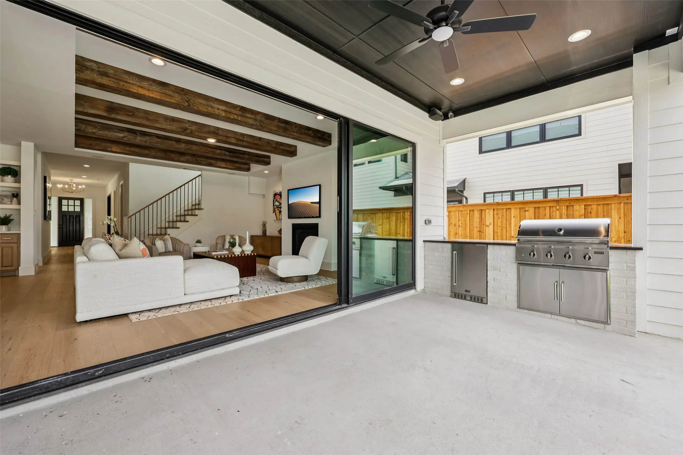Outdoor living area featuring a built-in grill, under-counter refrigerator, and a ceiling fan