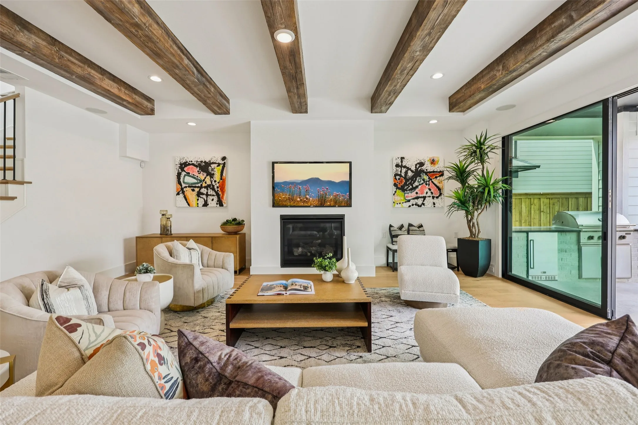 Living area featuring exposed ceiling beams, a built-in fireplace, recessed lighting, wood-finish flooring, and a large sliding glass door