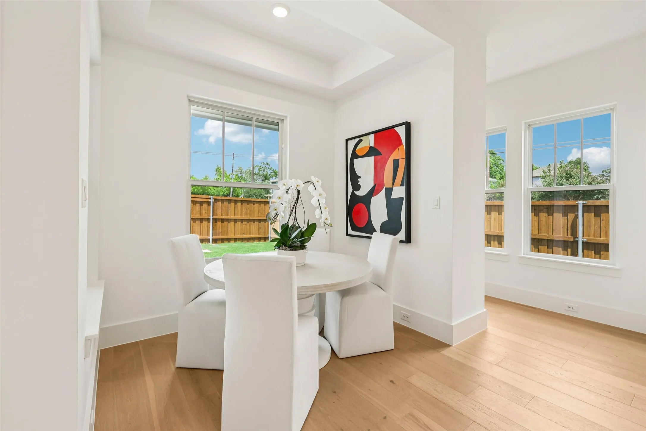 Recessed lighting, light wood-finish flooring, multiple windows, and a coffered ceiling