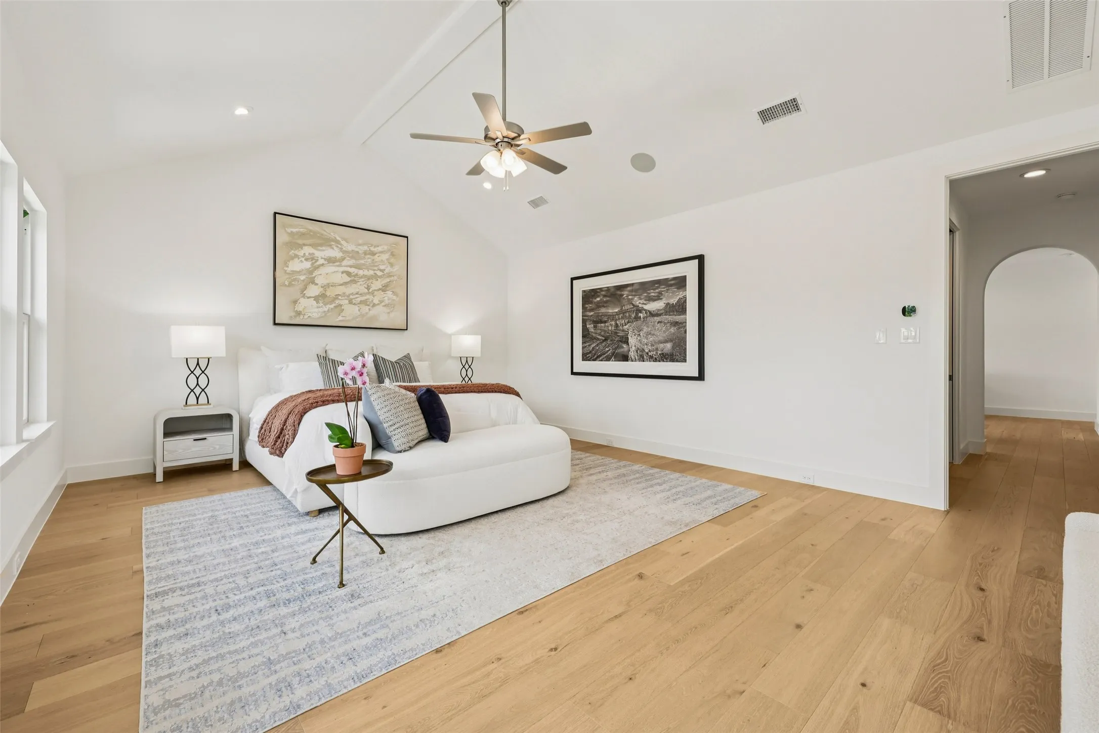 Vaulted ceiling with a ceiling fan, recessed lighting, wood-finish flooring, and an arched doorway