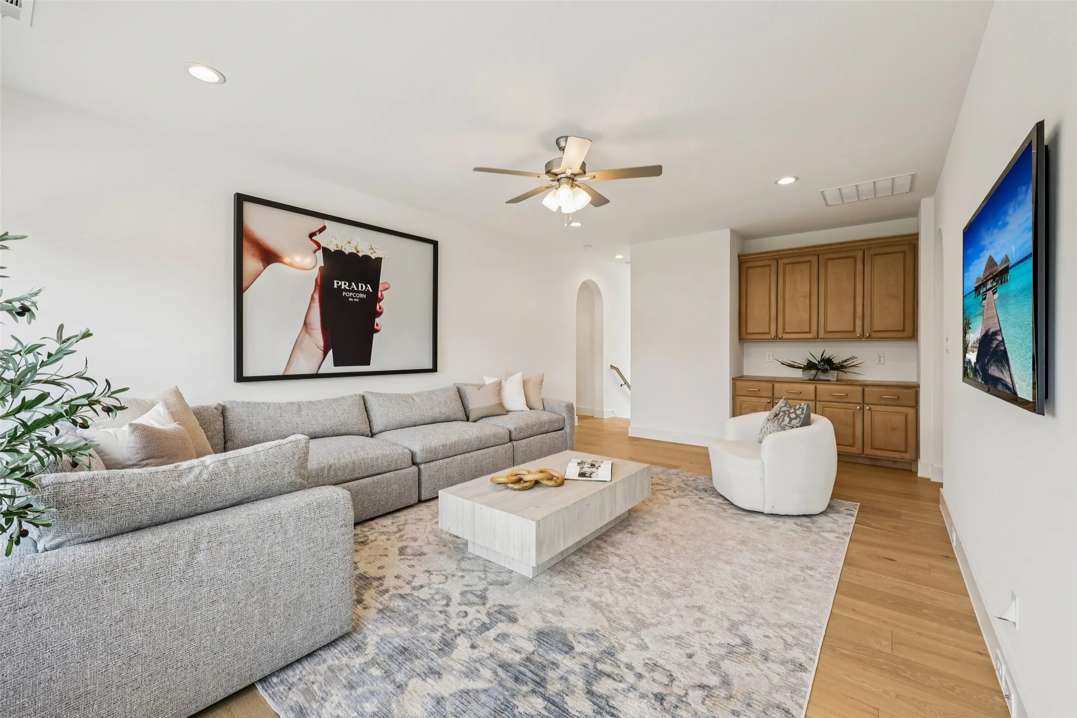 Recessed lighting, ceiling fan, wood-finish flooring, built-in cabinetry, and arched doorway