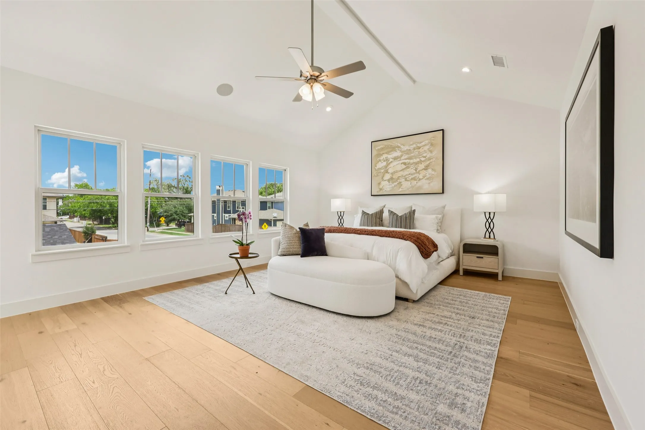 Vaulted ceiling with a ceiling fan, recessed lighting, and integrated speaker