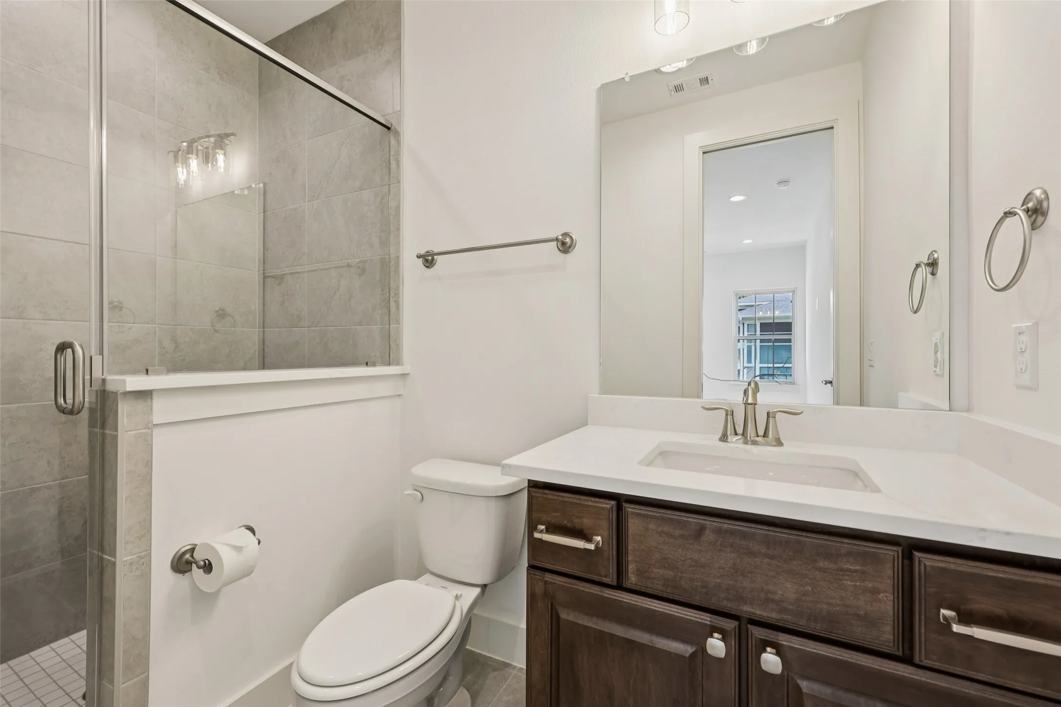 Vanity with dark wood-finish cabinetry, white countertop, and under-mount sink