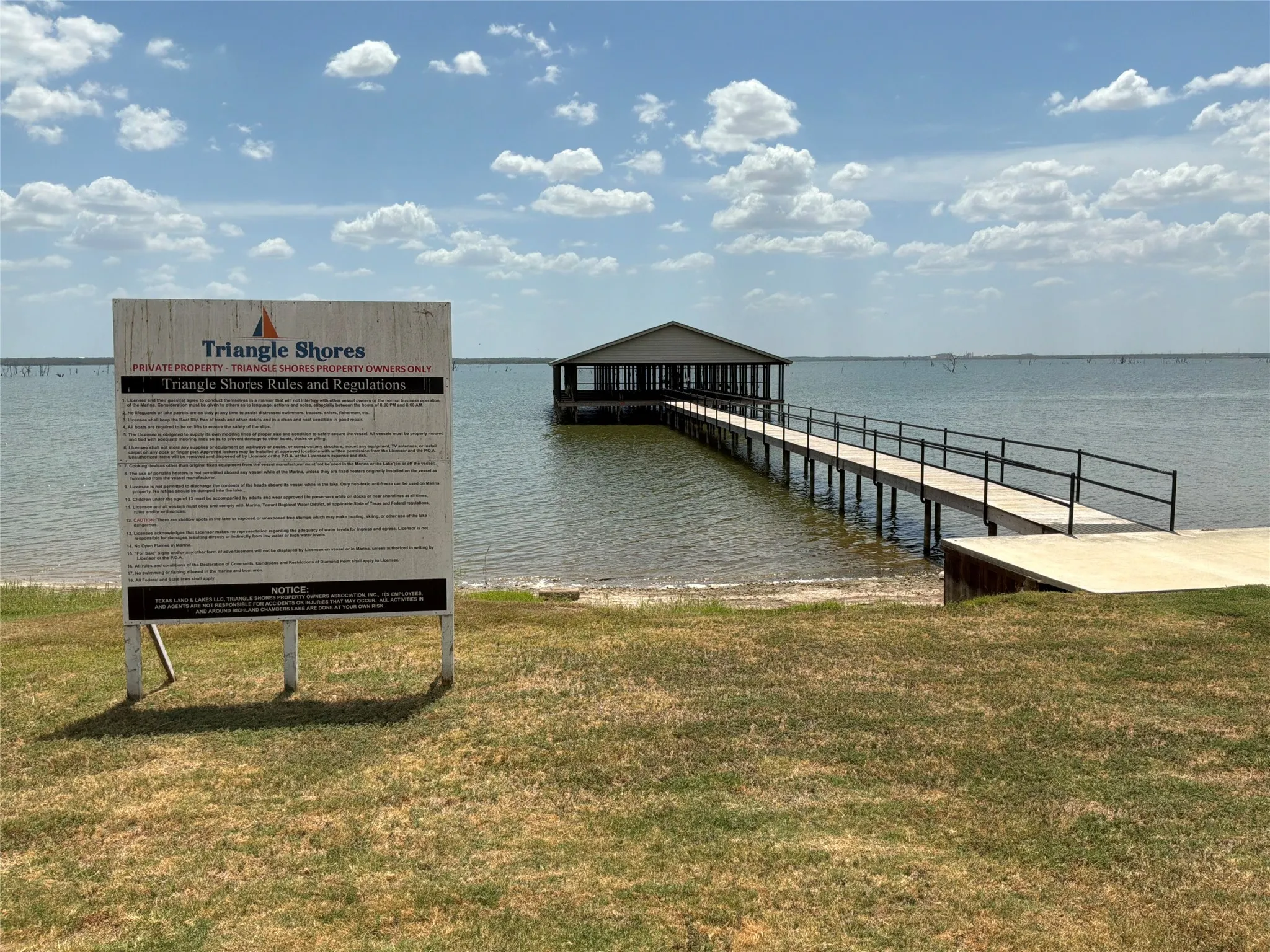 Waterfront property featuring a private boat dock, covered boat house, and an expansive body of water