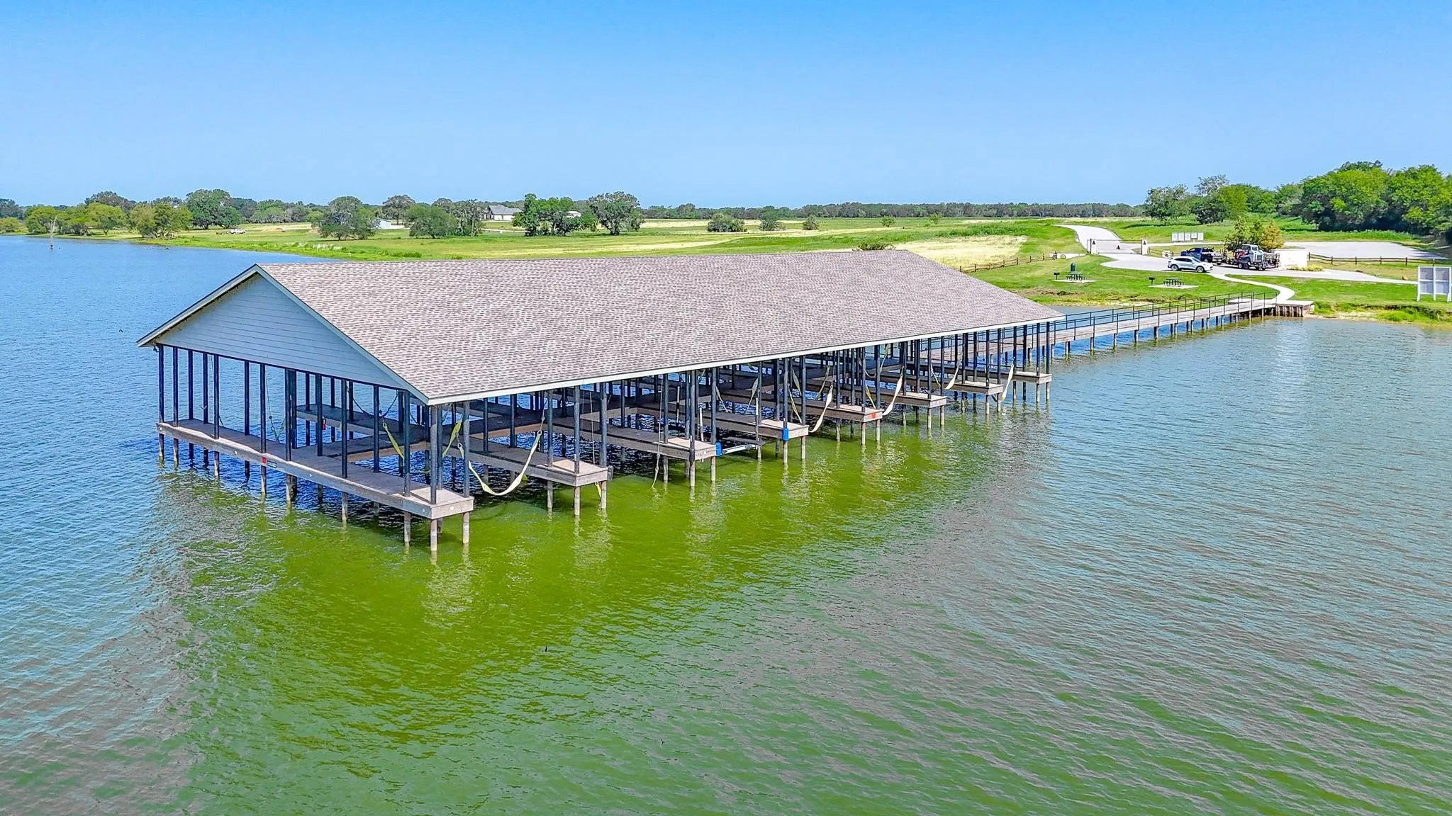 Multi-slip covered boat dock with a substantial pier extending to the shoreline
