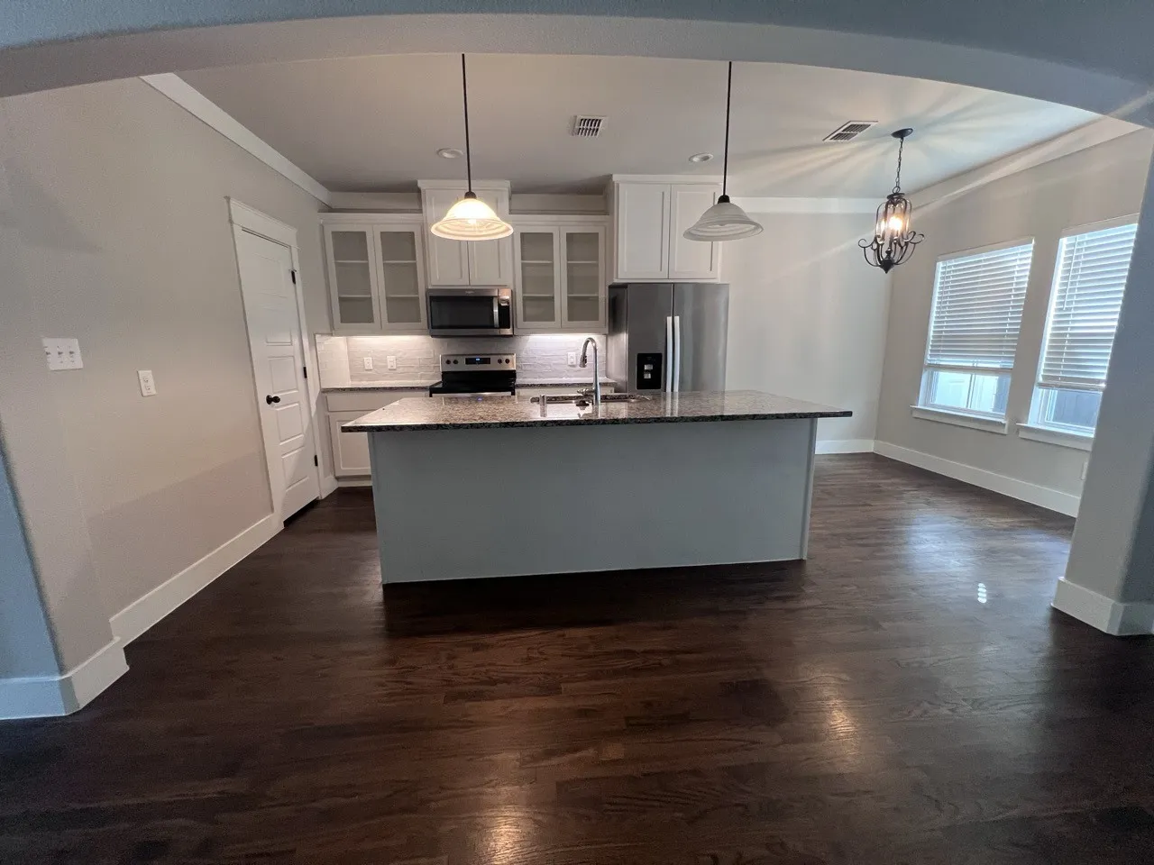 Kitchen featuring a central island, recessed lighting, stainless steel appliances, and wood-finish flooring