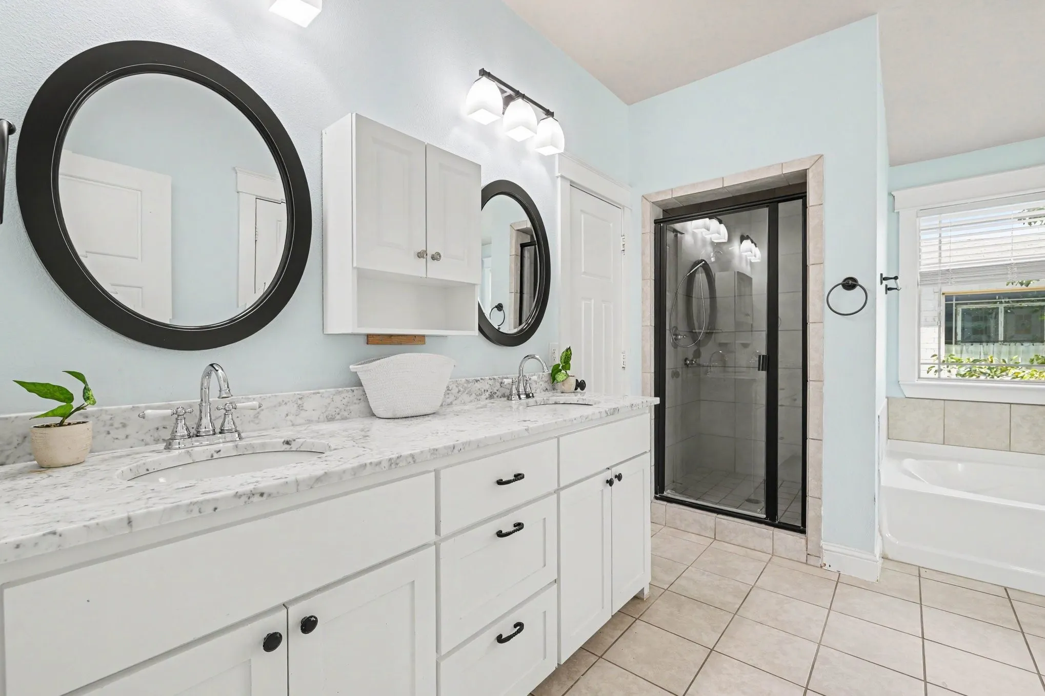 Dual vanities with white cabinetry and stone countertops