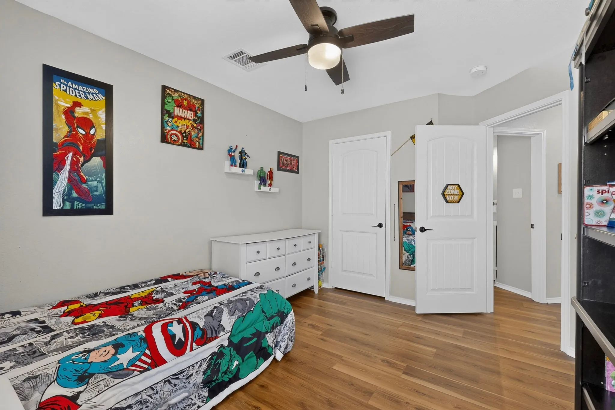 Wood-finish flooring throughout, ceiling fan with integrated lighting, and white paneled doors