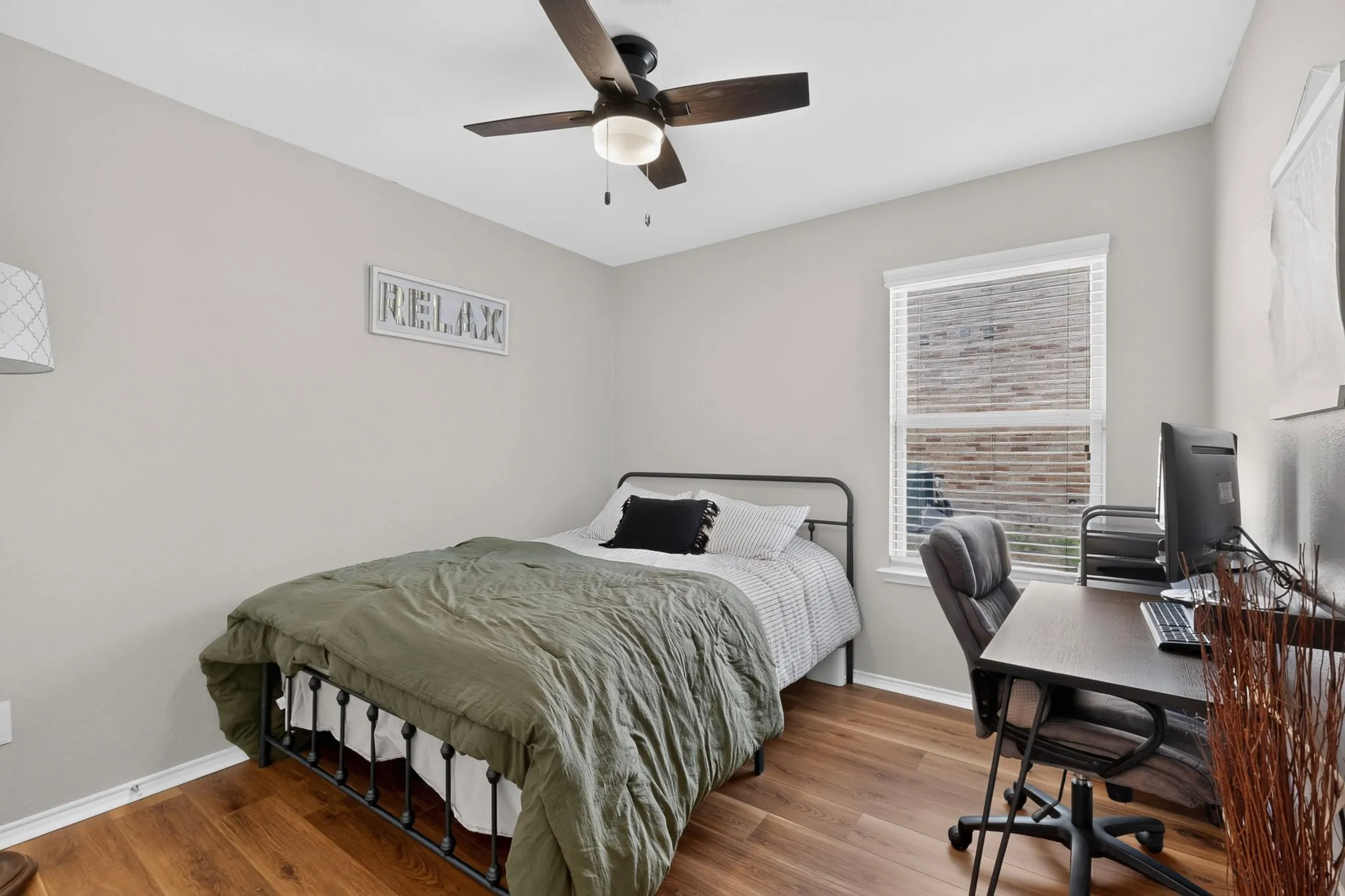 Wood-finish flooring throughout, with a ceiling fan featuring a light kit