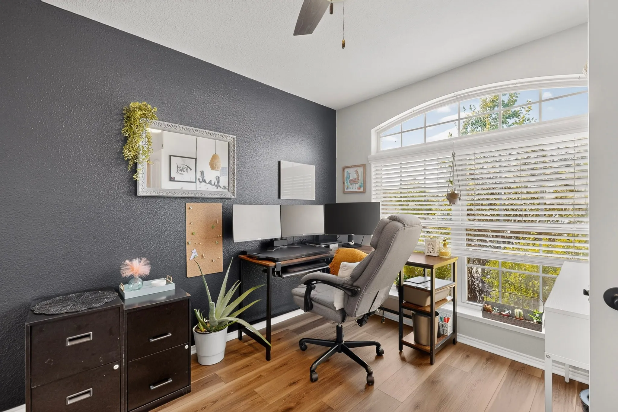 flex space or 4th bedroom with Arched window with blinds, wood-finish flooring, textured wall, and ceiling fan