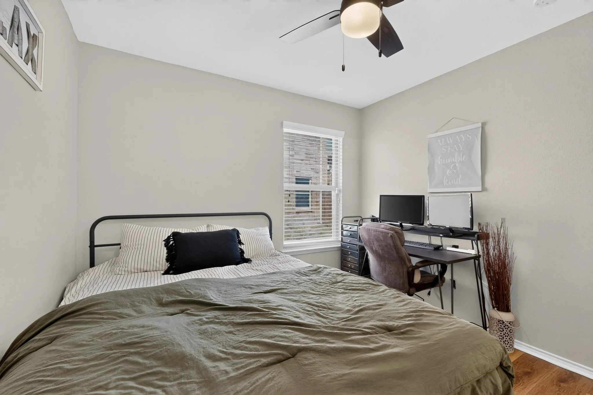 Ceiling fan with light fixture, window with blinds, wood-finish flooring, and light neutral wall paint