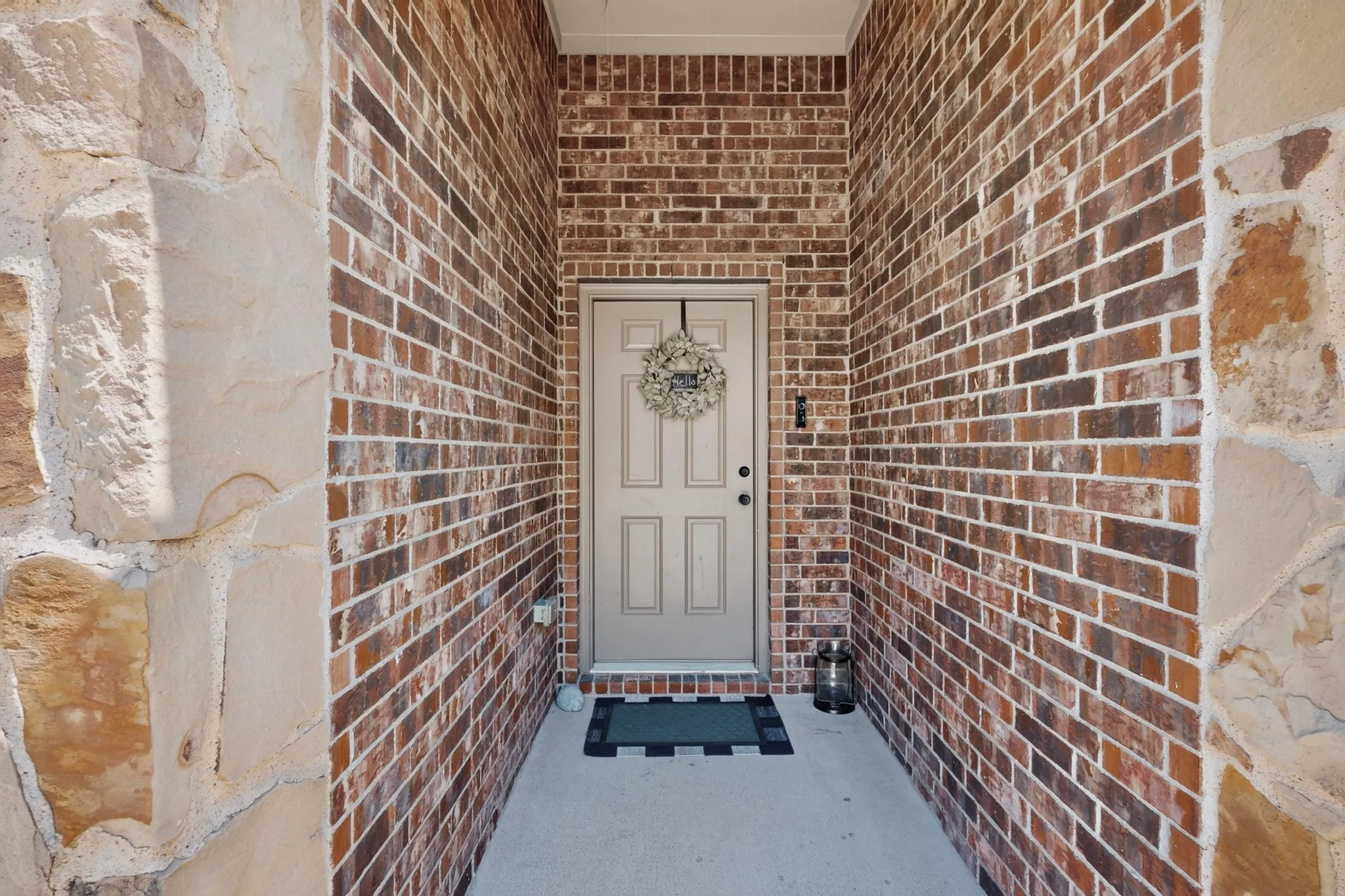 Brick and stone exterior with a paneled entry door