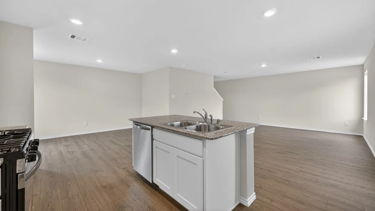 Kitchen island with a double basin sink, stainless steel dishwasher, and granite countertop