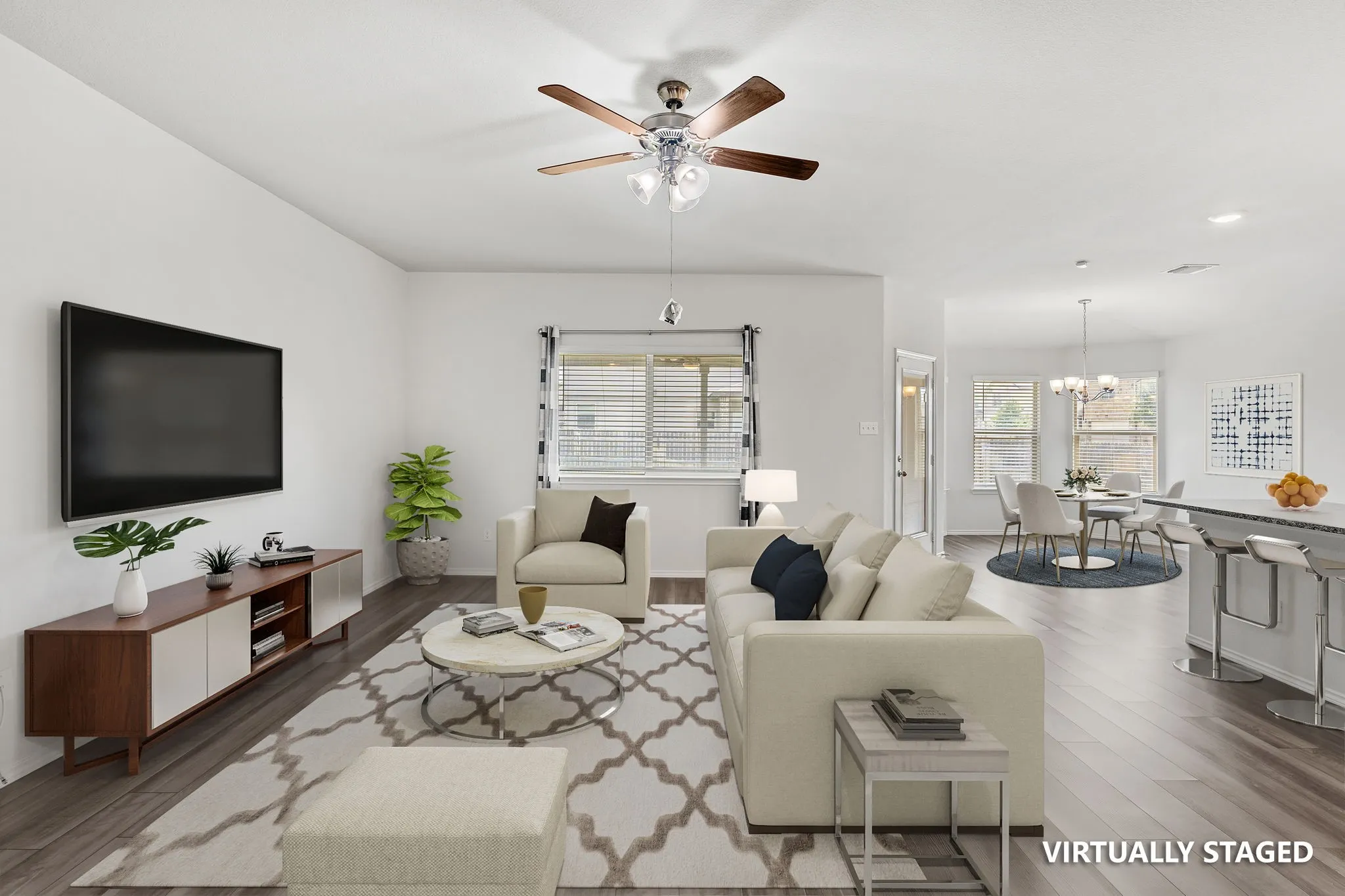 Virtually Staged Open-concept living space with wood-finish flooring, a ceiling fan, and a dining area with a chandelier