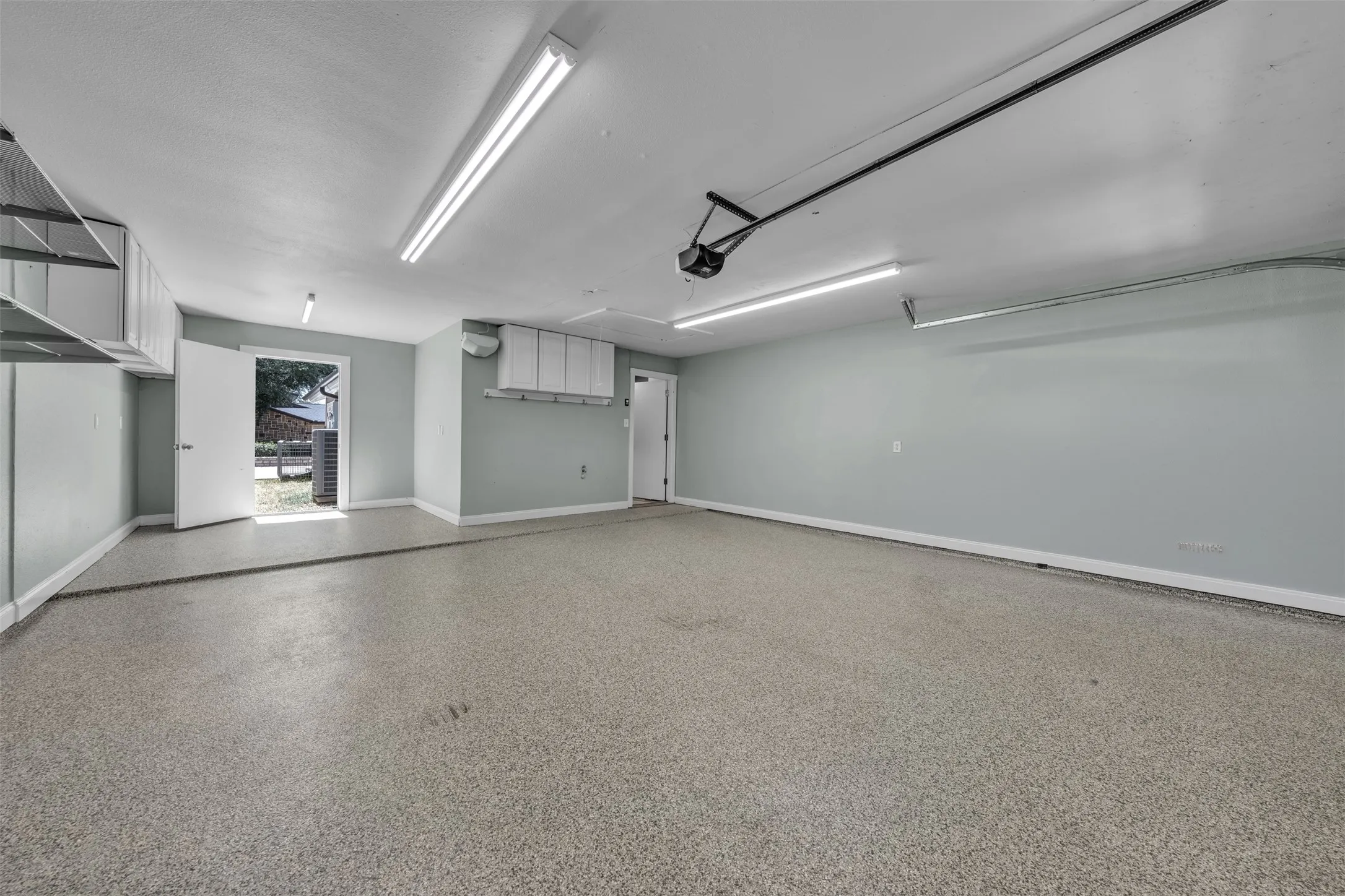 Workshop area has cabinets and opens to outdoor courtyard space