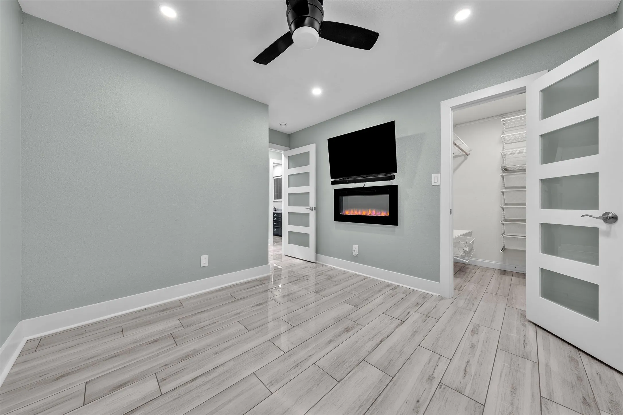 Second bedroom with custom closet, fan and fireplace