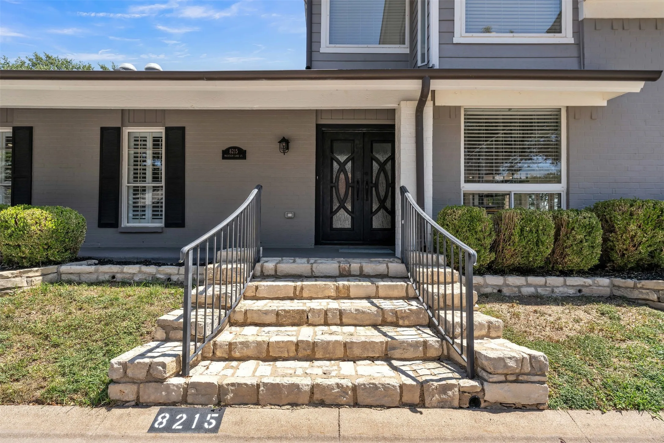 Welcome Home. Custom iron double doors and stone steps to street.