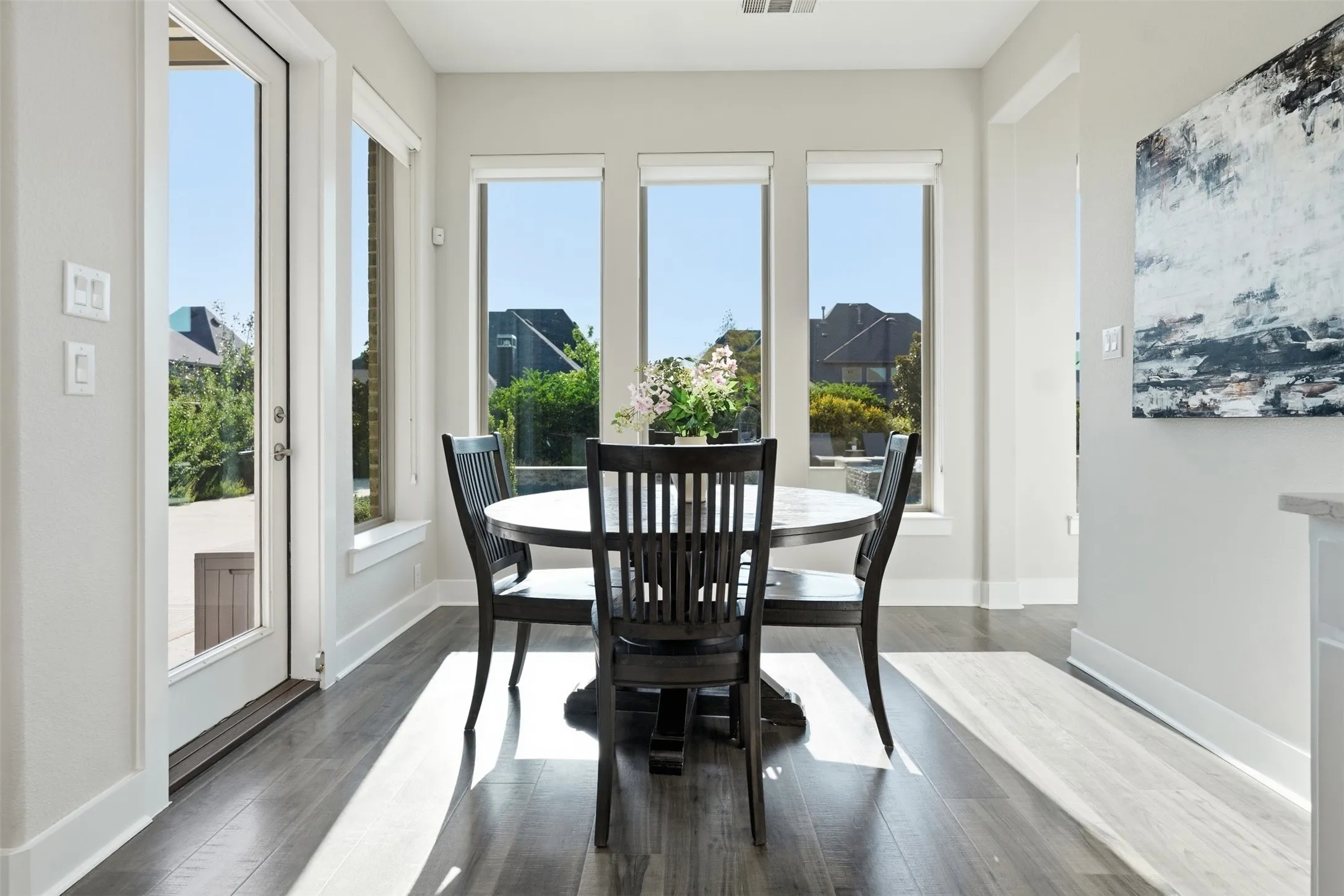 Recessed lighting, wood-finish flooring, white trim, and multiple large windows