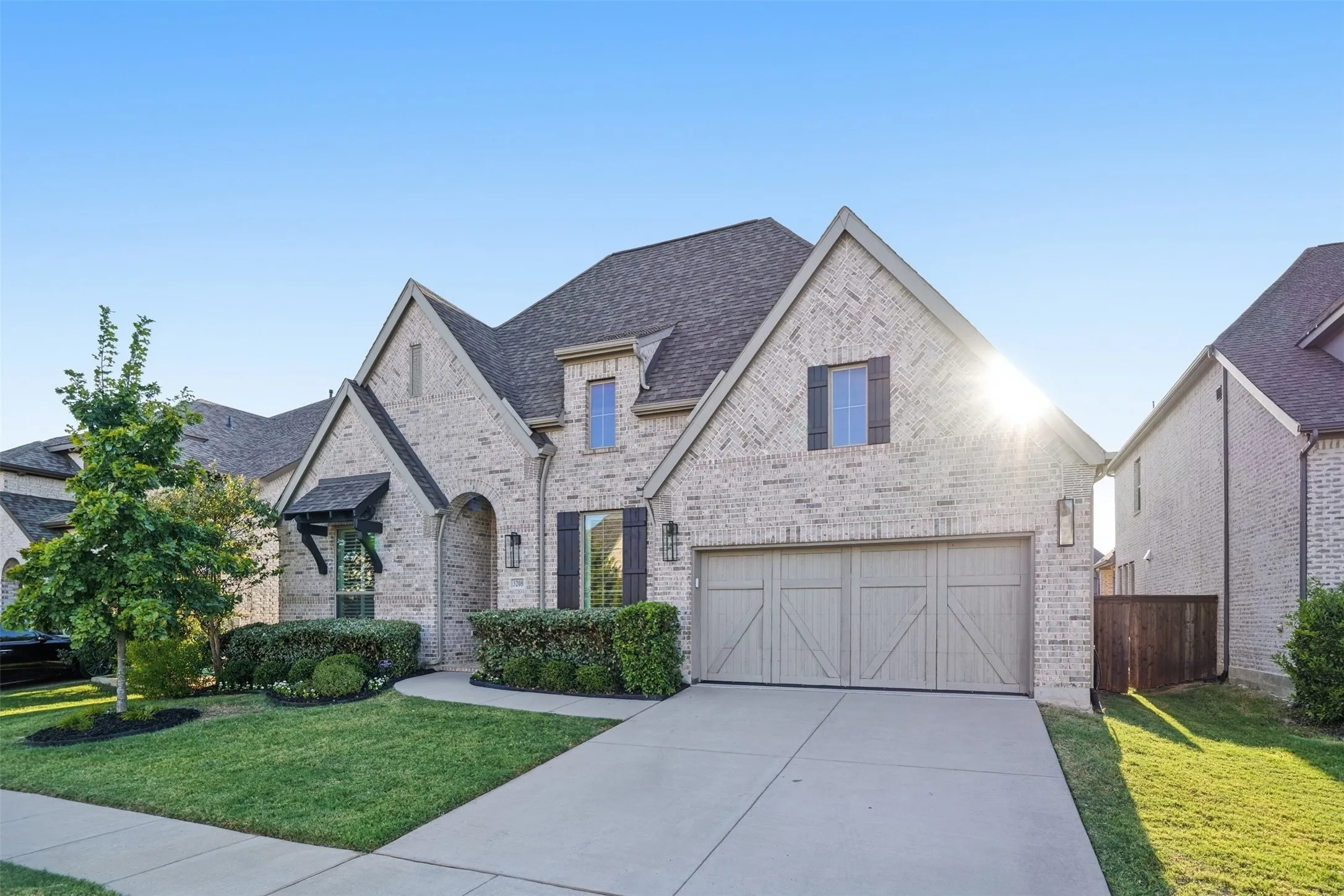 Brick exterior with a gabled roofline, featuring a two-car garage with a wood-look door