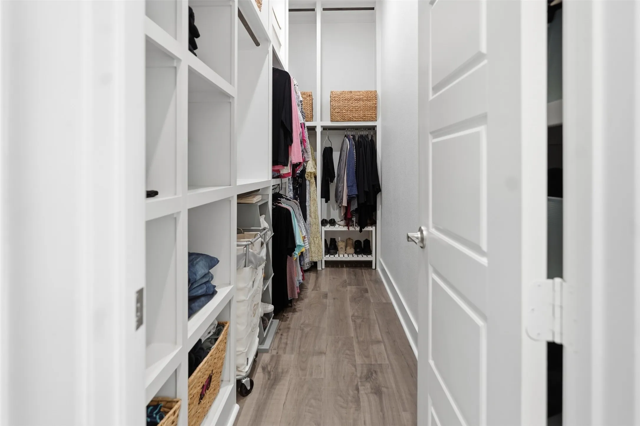 SEPERATED CLOSETS - Custom closet system featuring extensive built-in shelving, integrated hanging rods, and wood-finish flooring