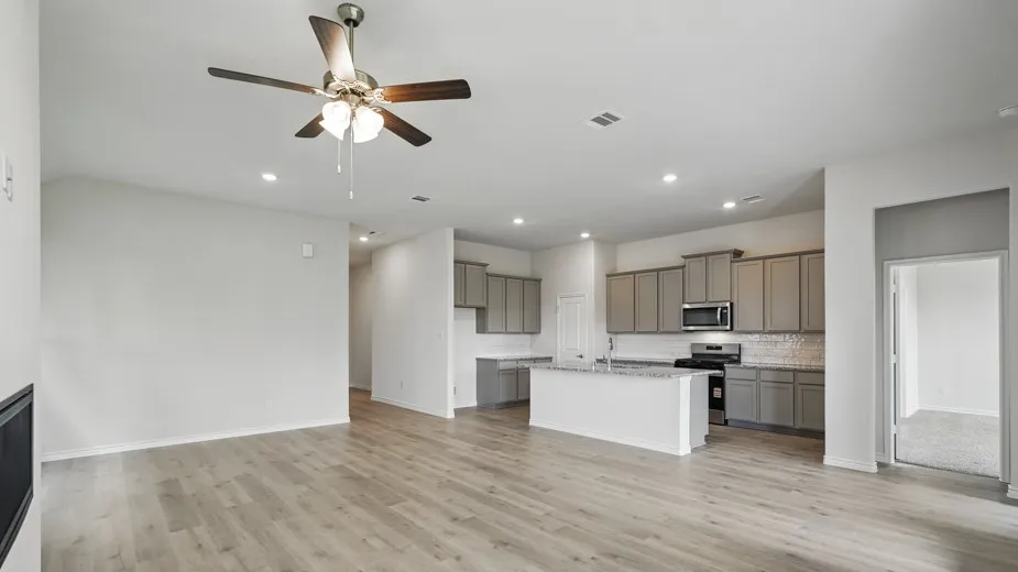 Open-concept living area featuring wood-finish flooring, recessed lighting, and a ceiling fan