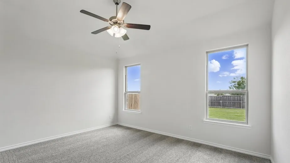 Neutral color palette, gray carpeting, dual windows, ceiling fan with light fixture, and white trim