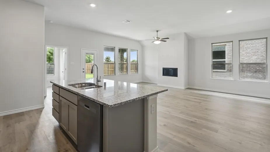 Kitchen island with integrated sink, stainless steel dishwasher, and granite countertop