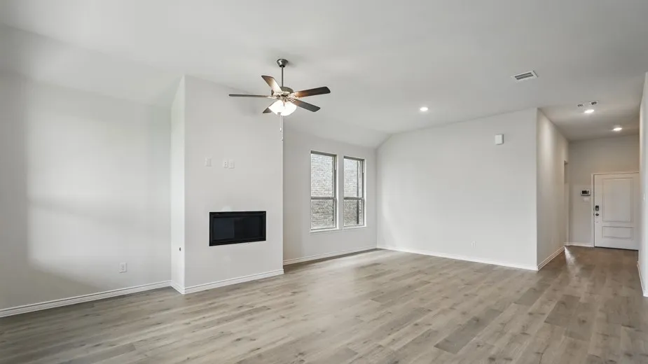Wood-finish flooring, recessed lighting, and a modern fireplace with a ceiling fan