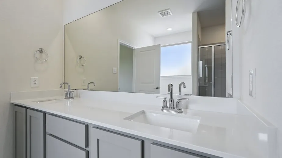 Dual vanity with undermount sinks, chrome fixtures, and light-toned countertops