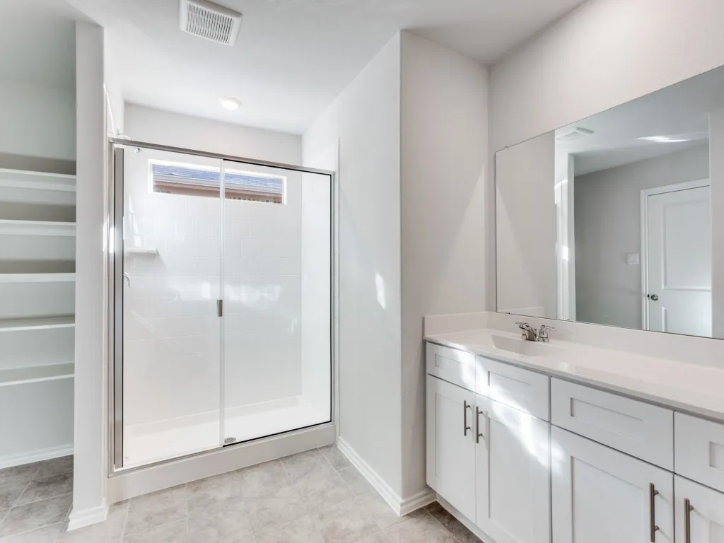 Spacious shower enclosure with sliding glass door