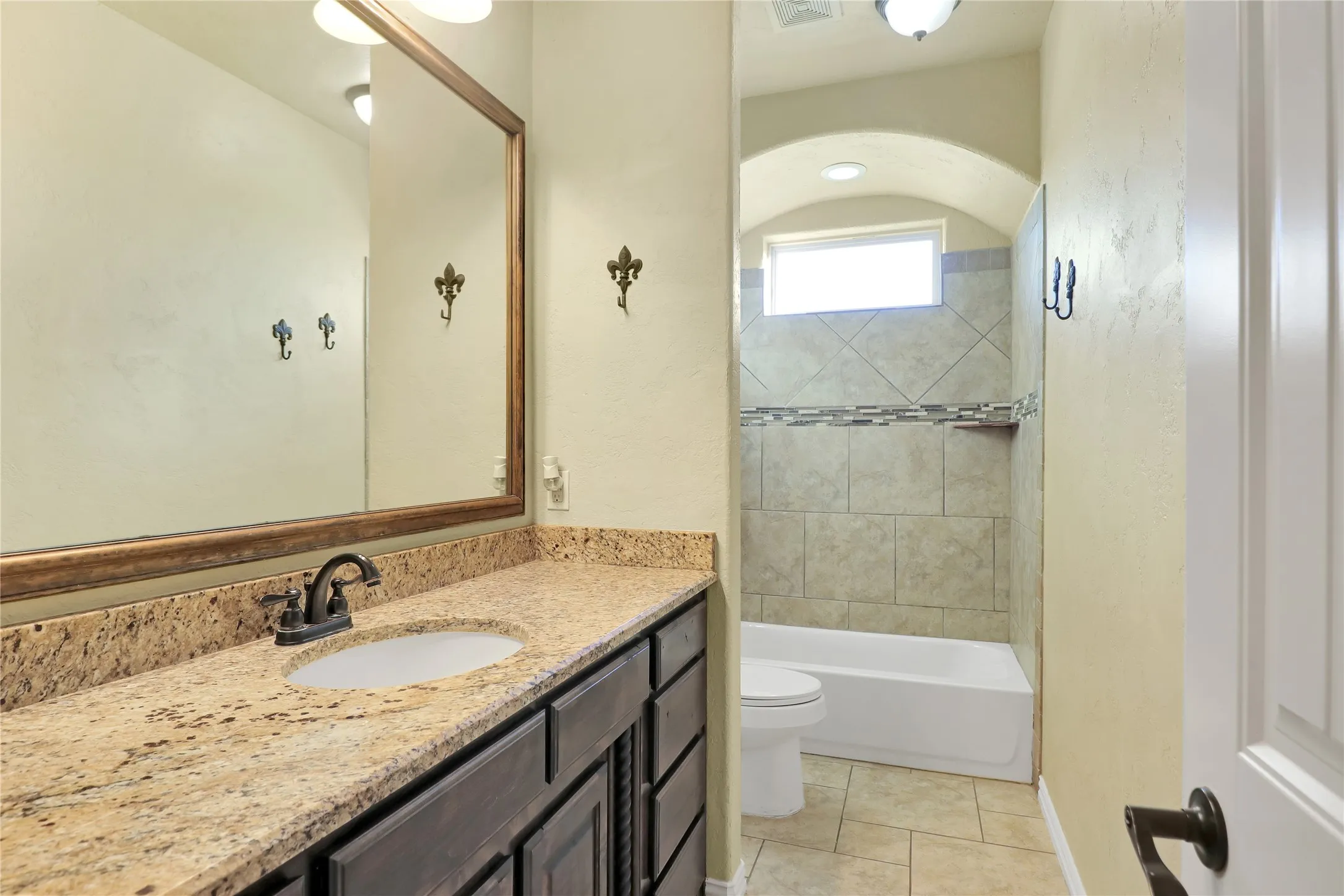 Extended vanity with a granite-style countertop, undermount sink, and dark wood-finish cabinetry