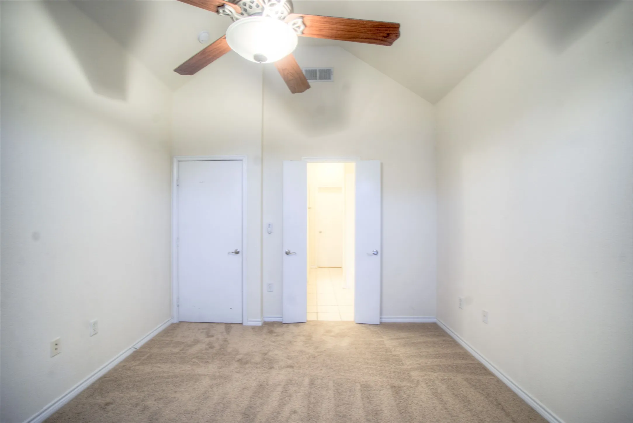 Vaulted ceiling with a wood-finish ceiling fan and integrated lighting