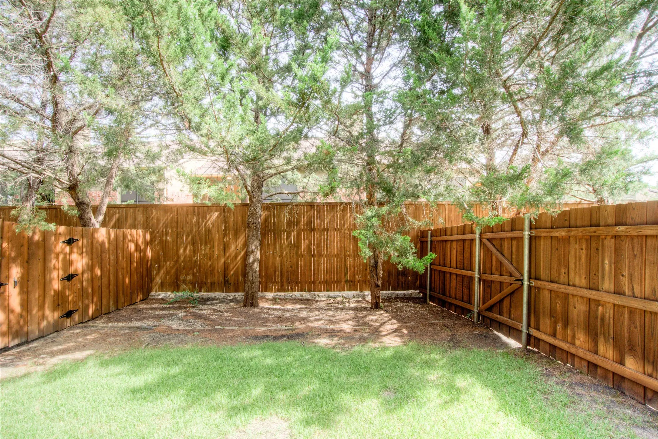 Private backyard featuring wood fencing and mature trees