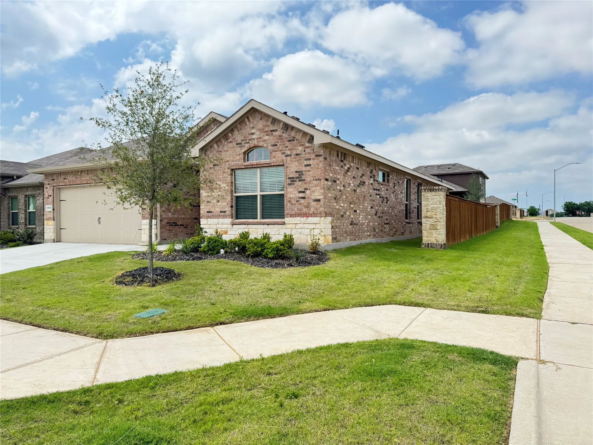 View of front facade with brick siding, a garage, and driveway