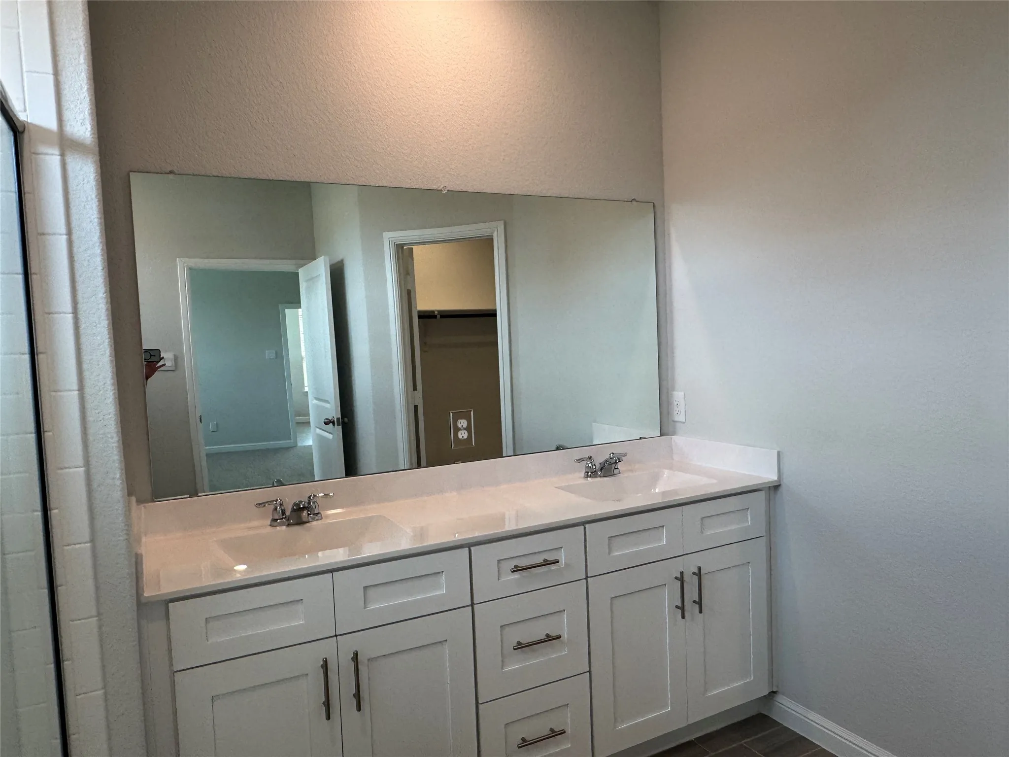 Bathroom with double vanity and baseboards