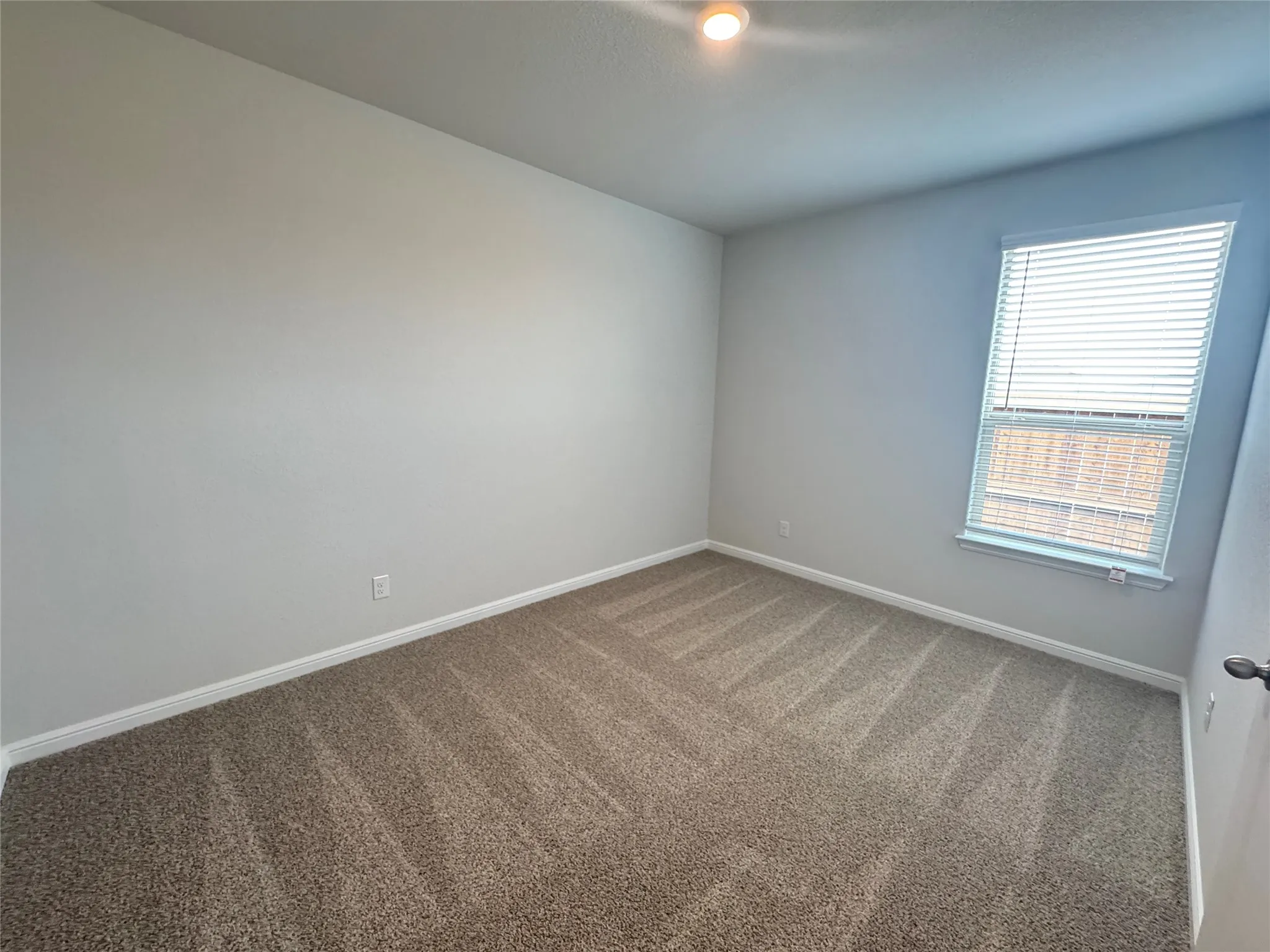 Carpeted empty room featuring baseboards