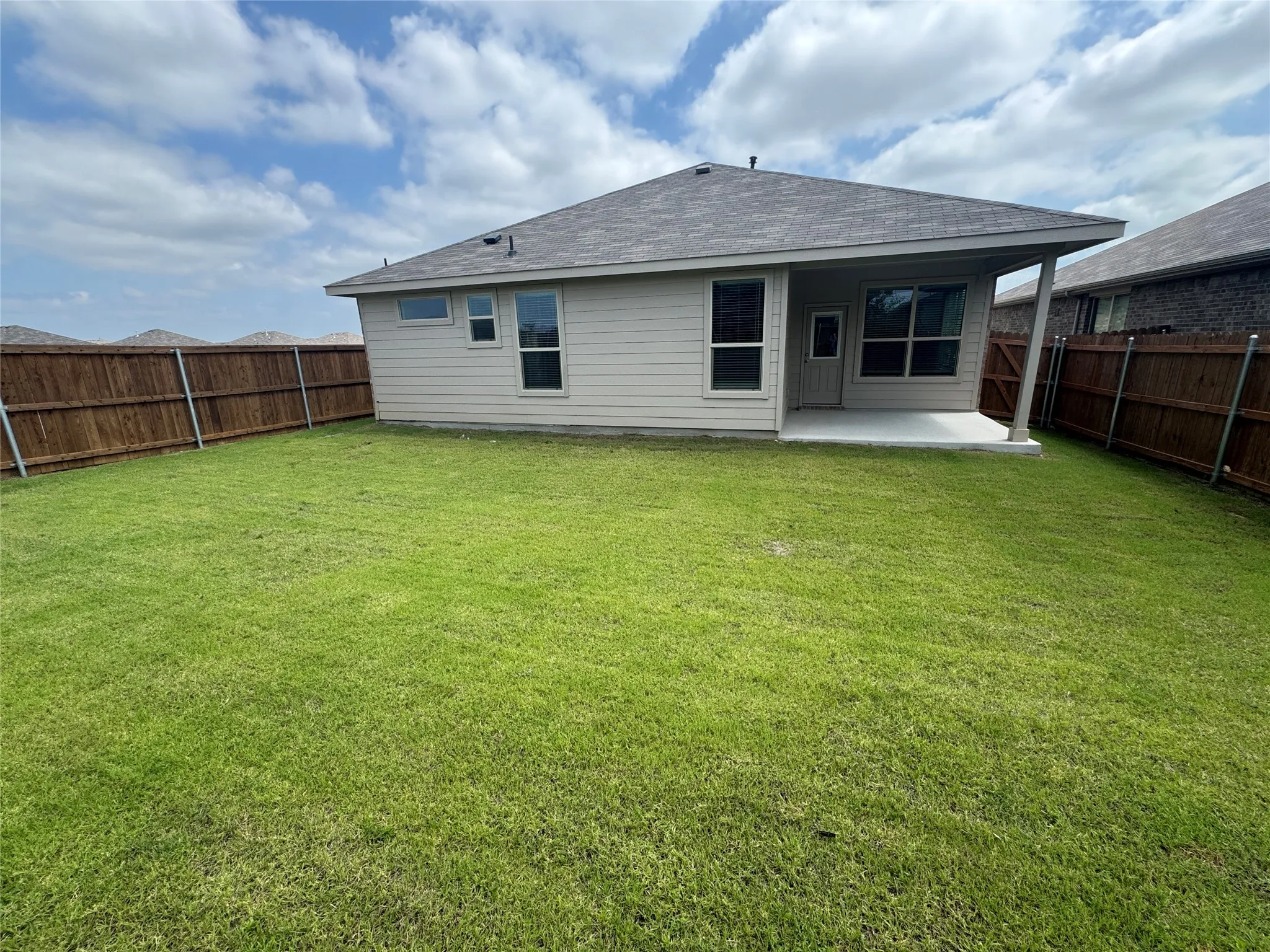 Rear view of house with a patio and roof with shingles
