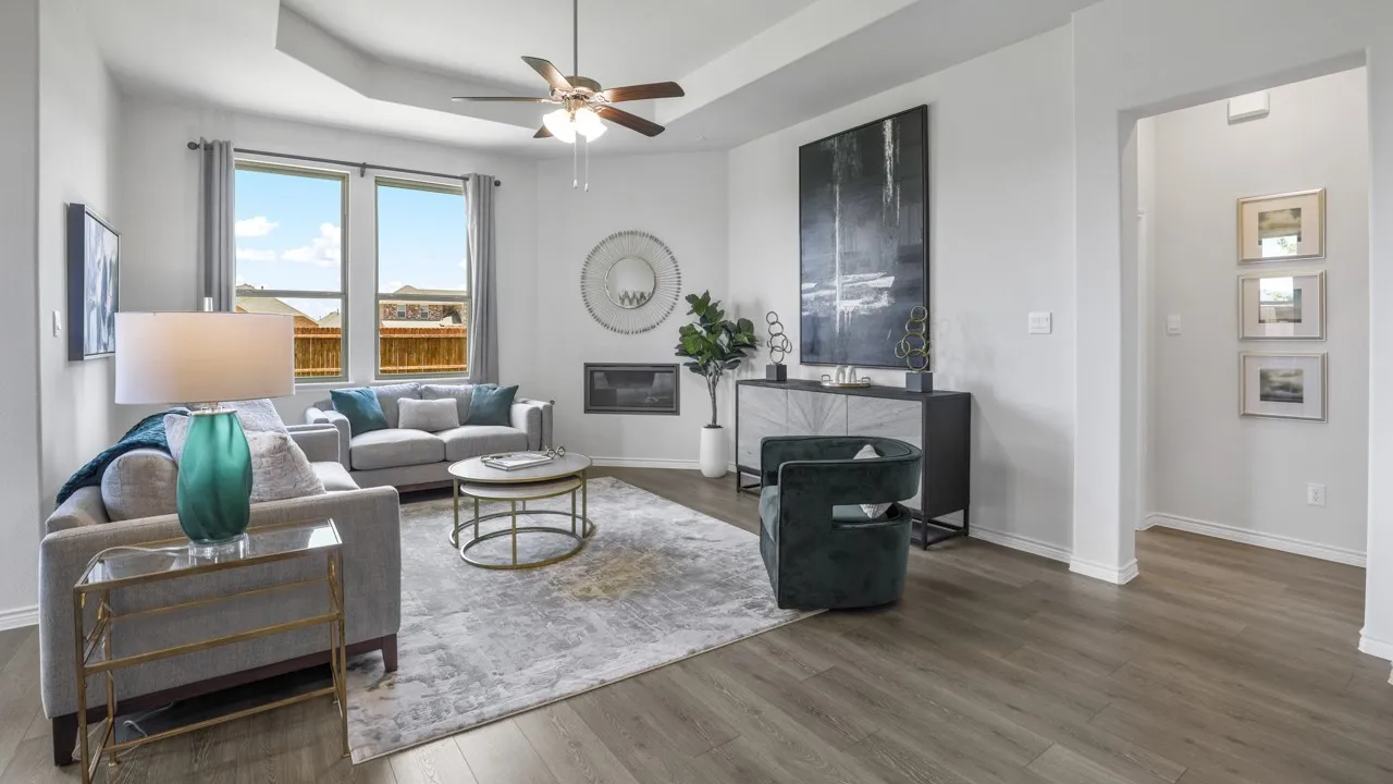 Spacious room featuring wood-finish flooring, a recessed ceiling with a ceiling fan, a built-in fireplace, and large windows