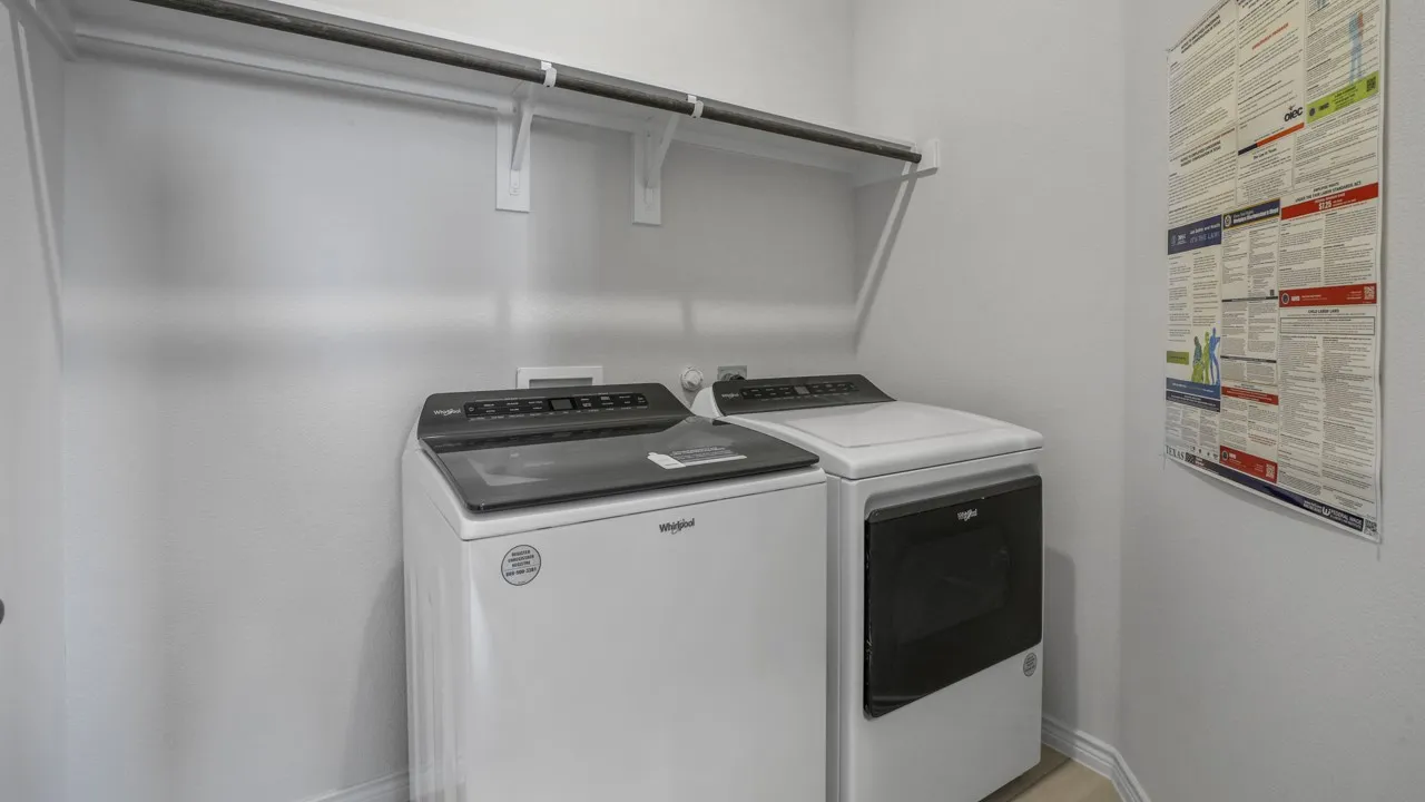 Laundry area featuring upper shelving and a clothes rod