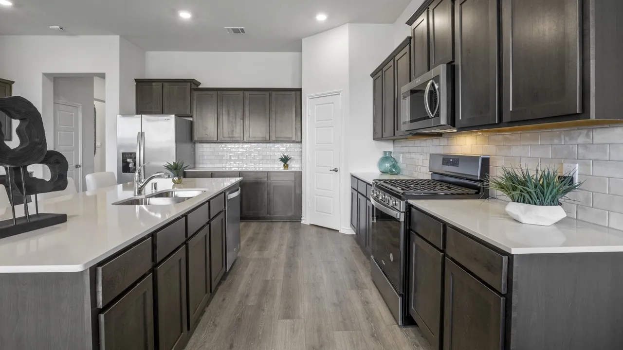 Kitchen featuring dark wood-finish cabinetry, light countertops, wood-finish flooring, stainless steel appliances, and subway tile backsplash