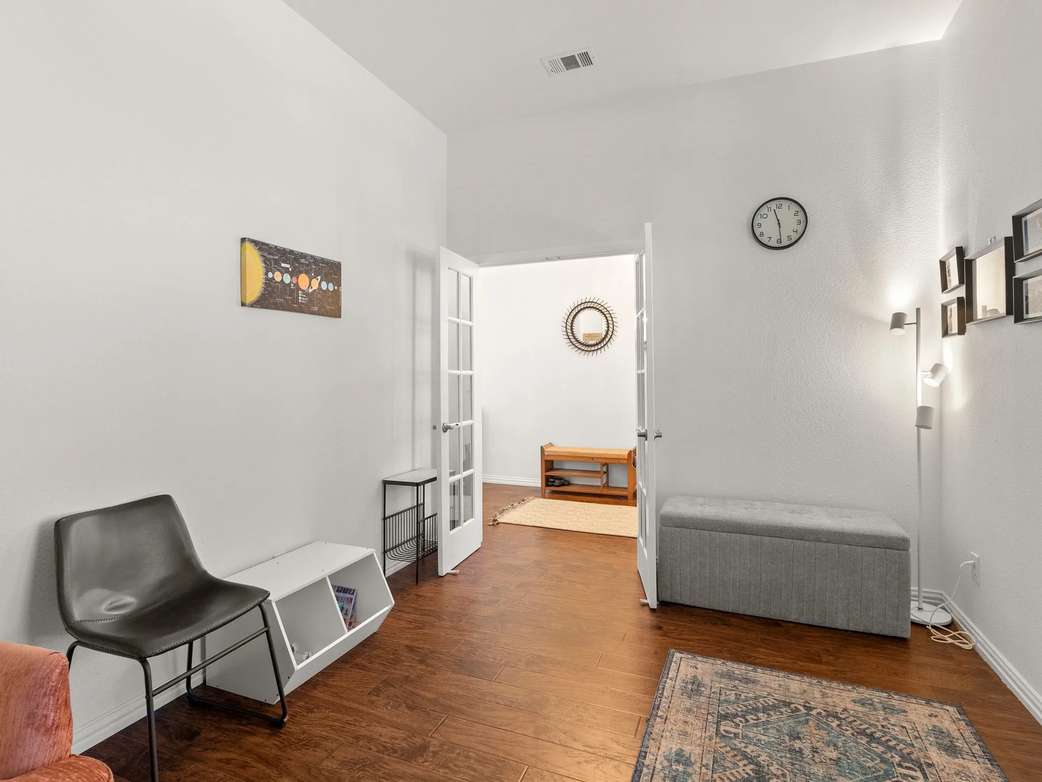 Wood-finish flooring throughout, white walls, and a white baseboard